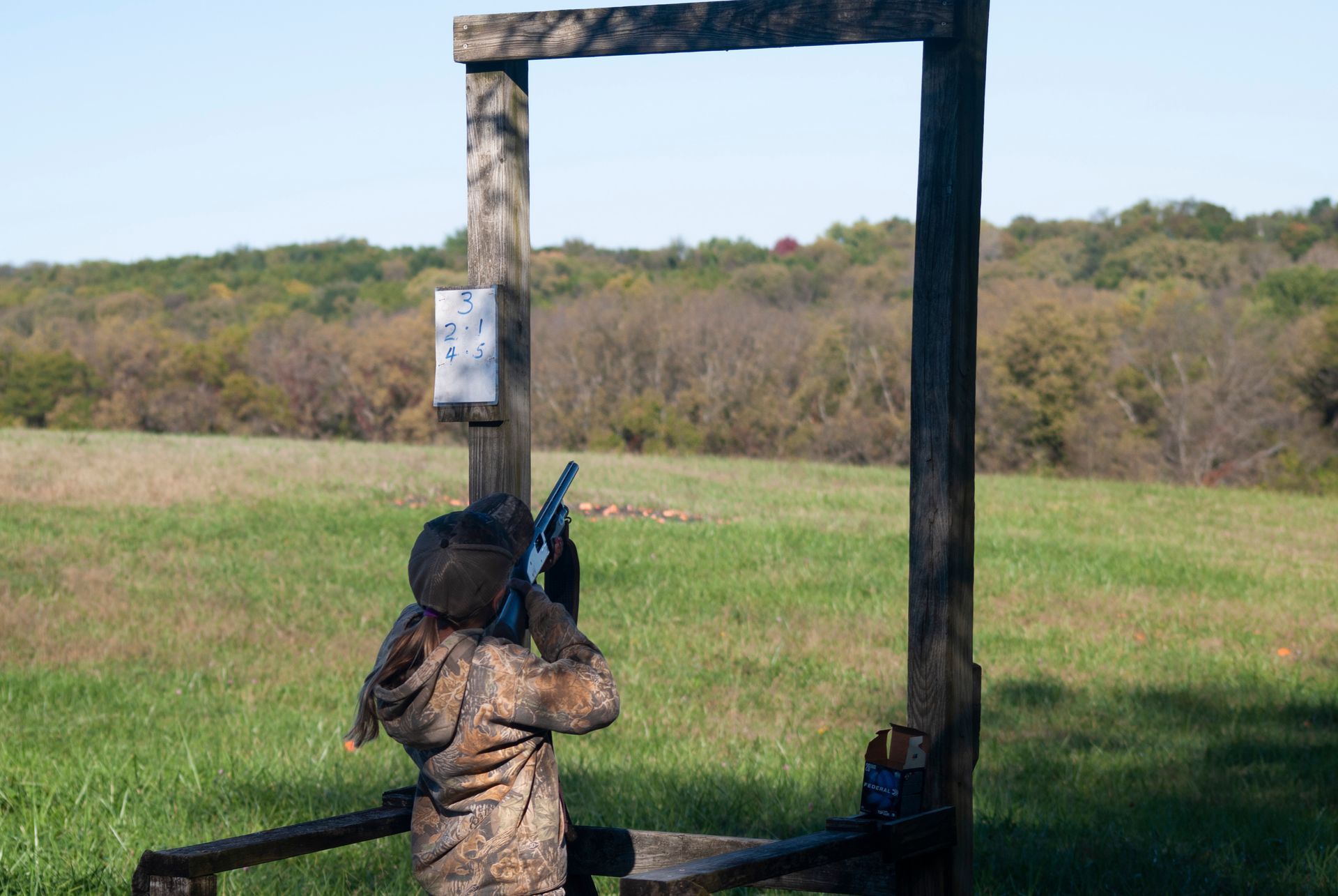 A child  points the gun to skeet shoot.