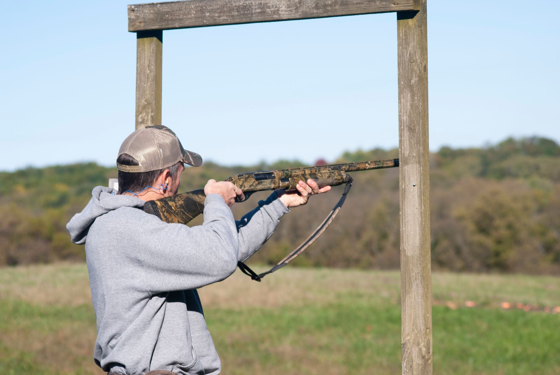 A man points his gun to skeet shoot.