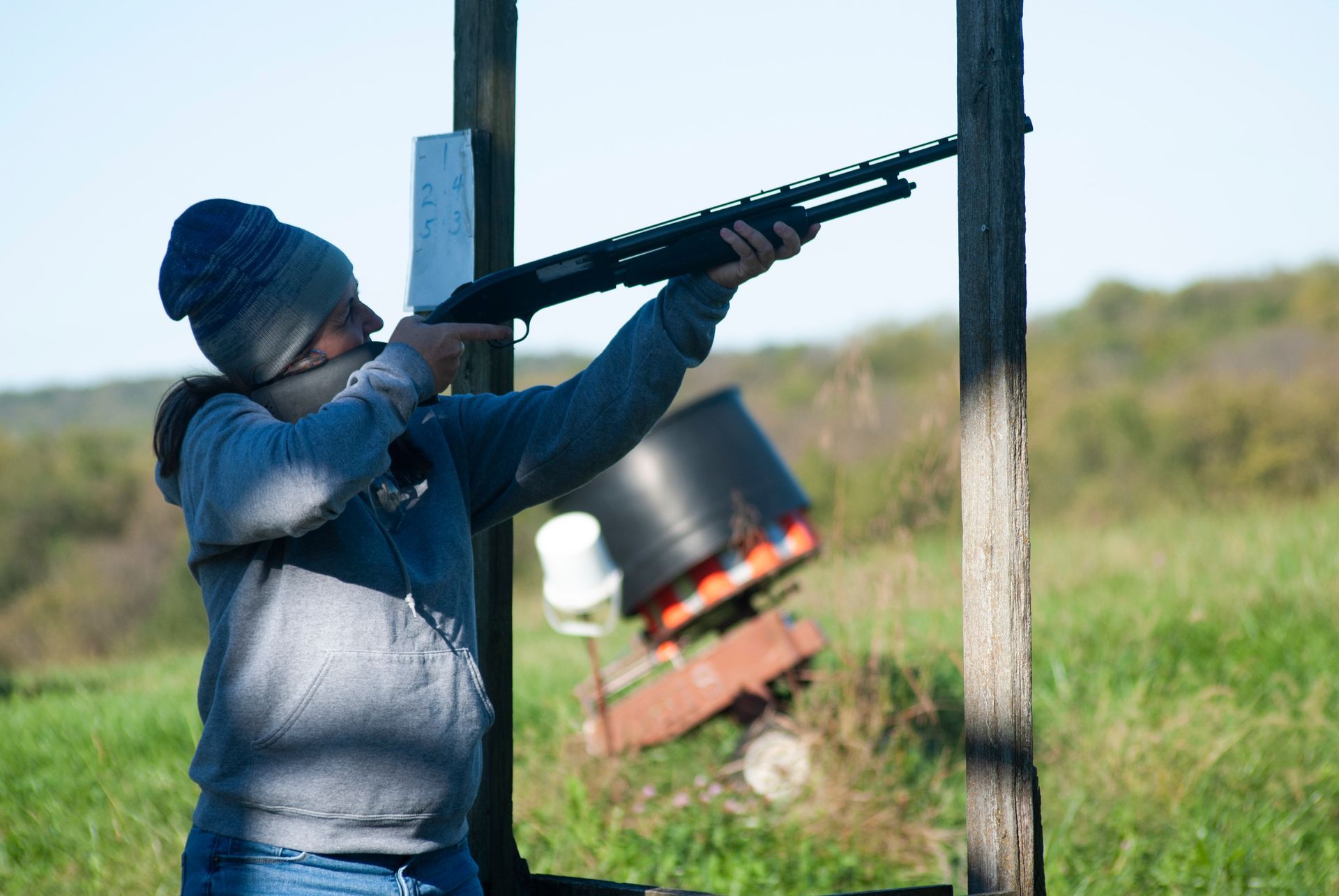 A woman is holding a gun at the skeet soot party.