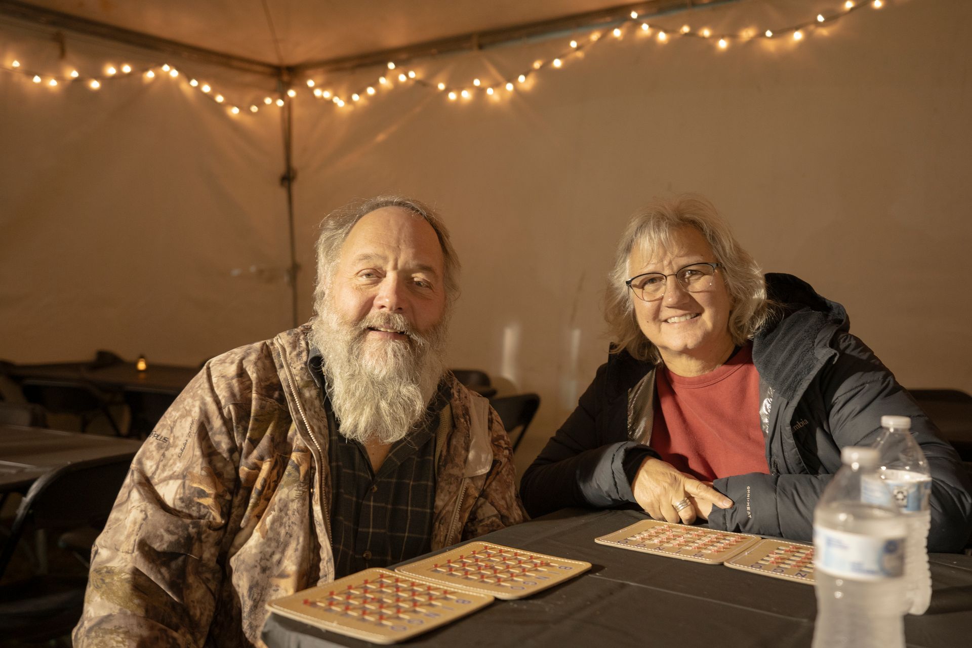 A man and a woman are sitting at a table playing bingo.