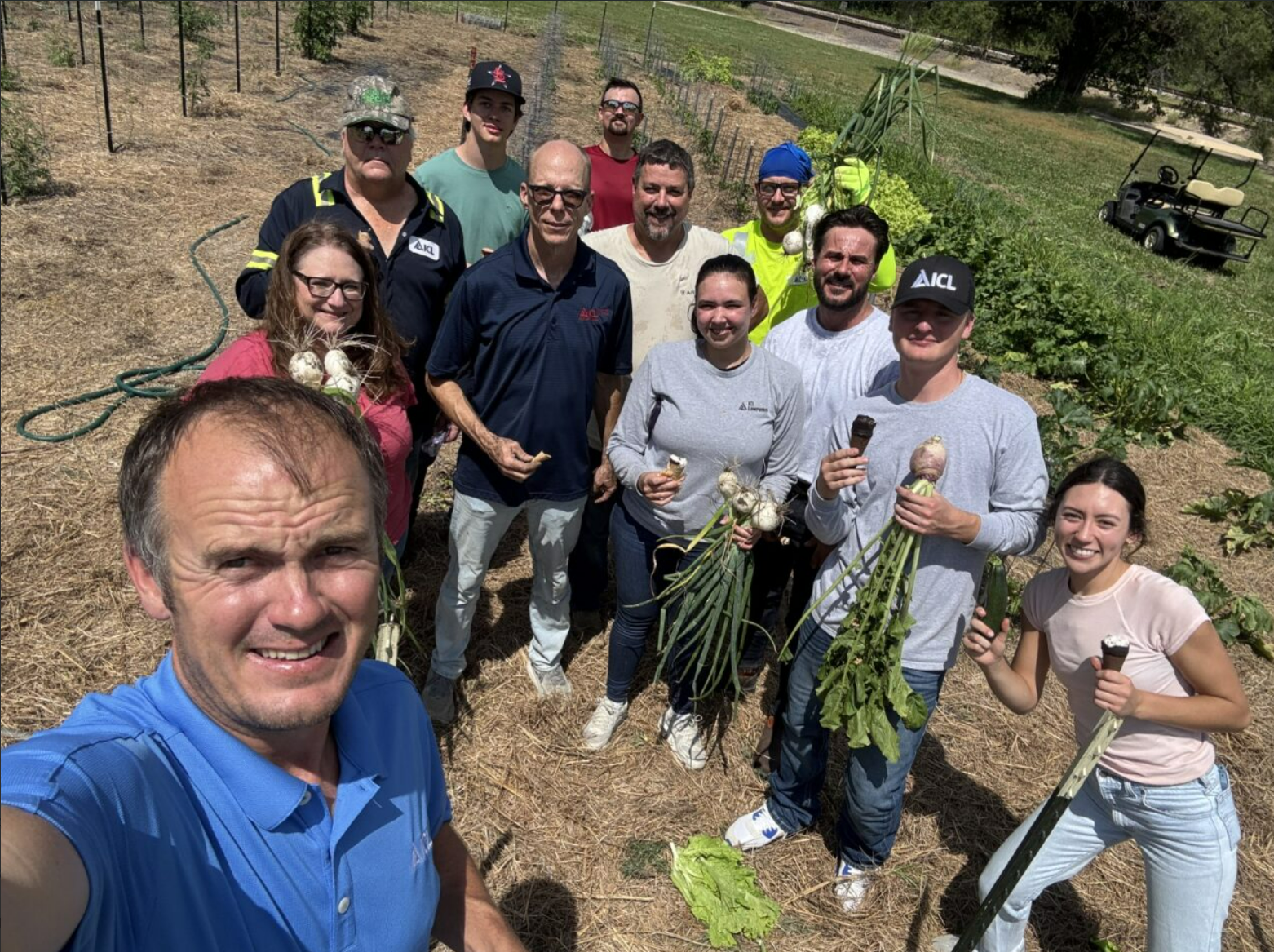ICL Lawrence staff stand together to  after cleaning up garden