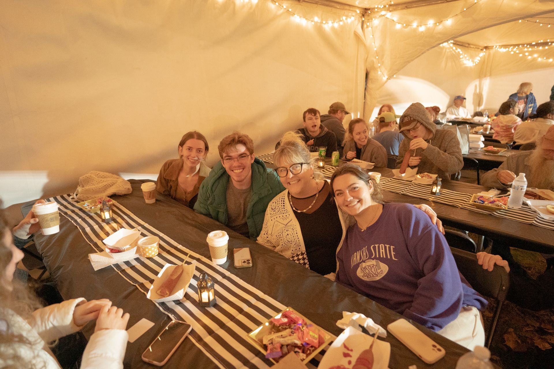 A group of people are sitting at a long table eating food.