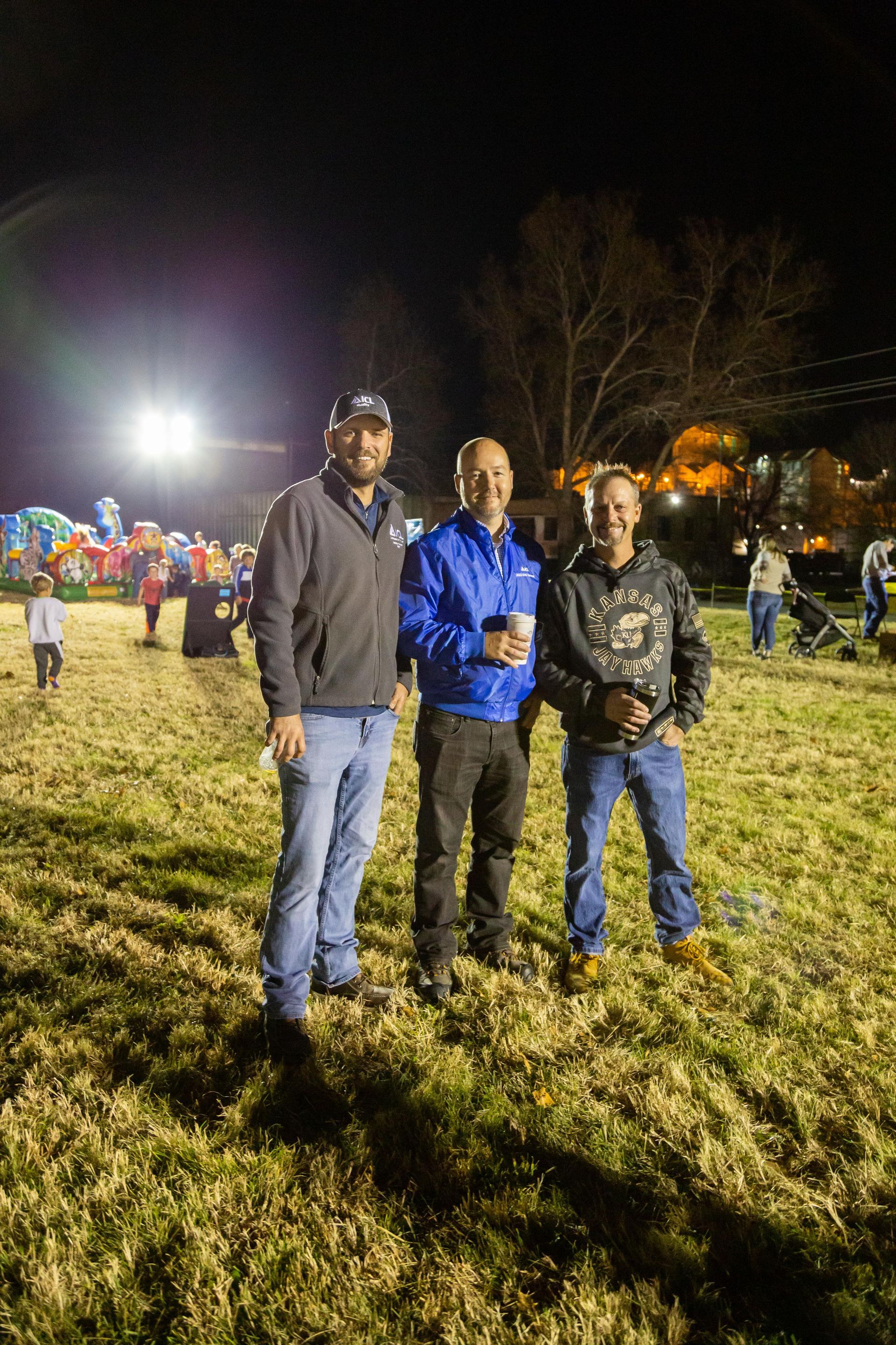 Three men standing and smiling for the camera.