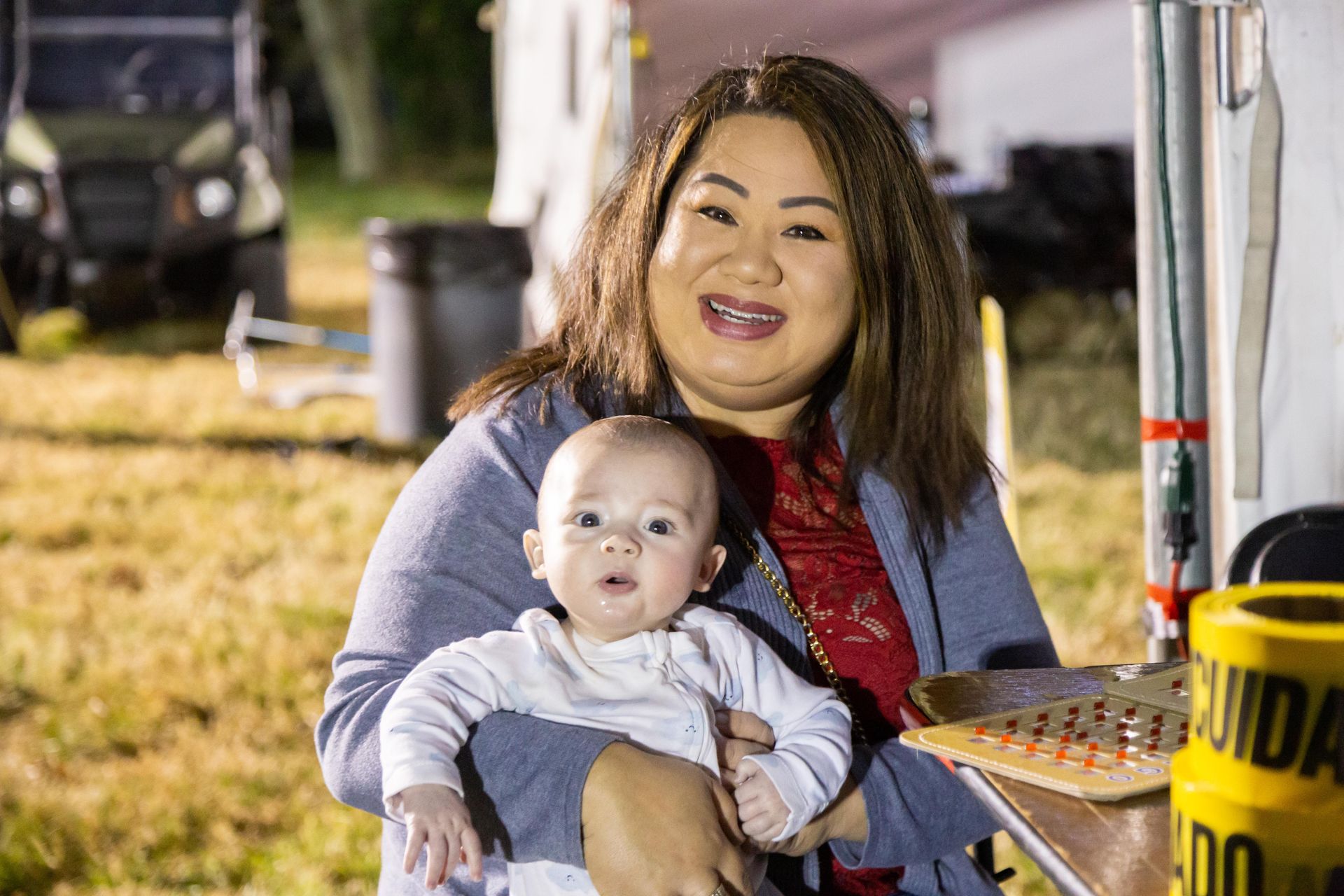 A woman holds a baby and smiles.