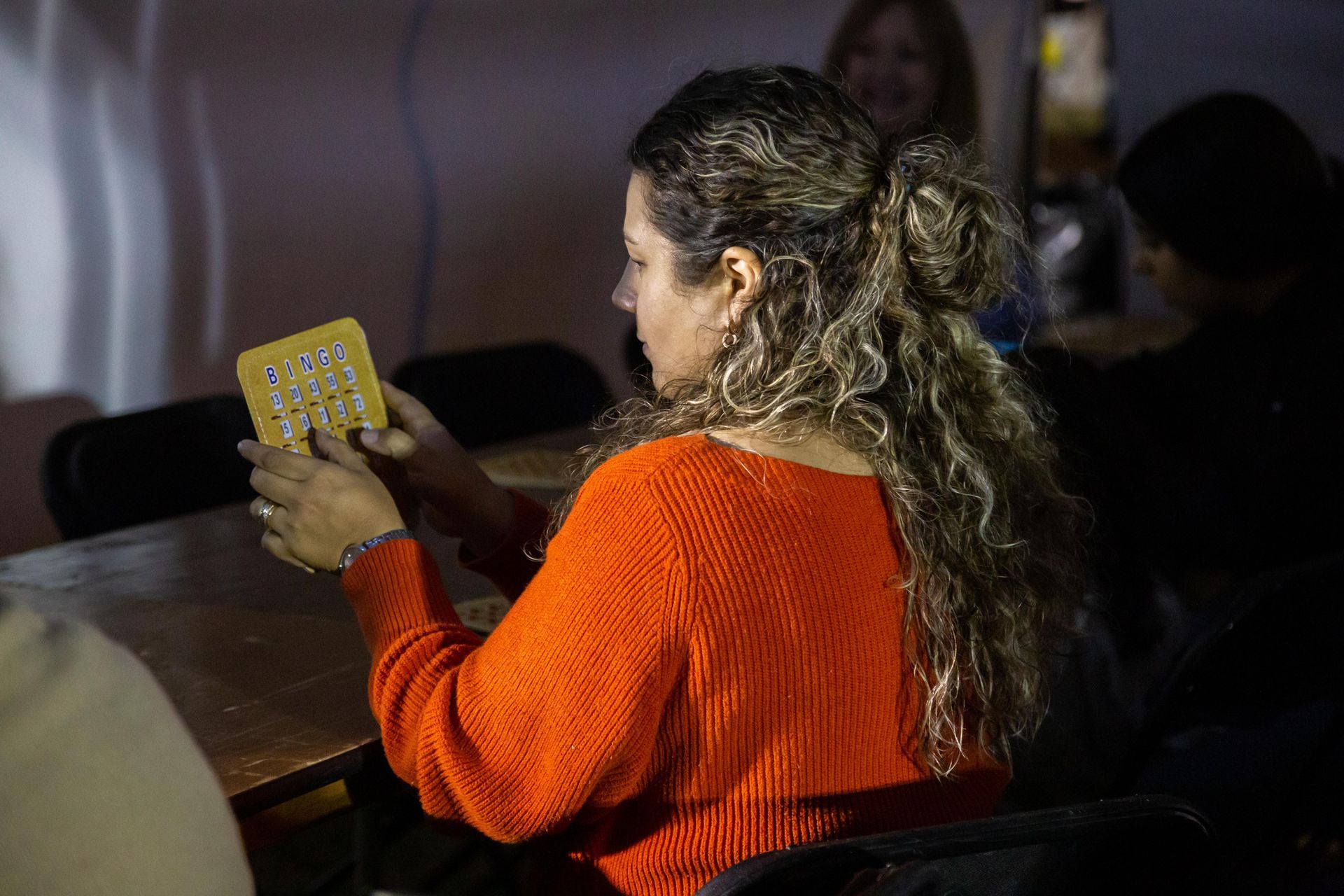 A woman is playing a game of BINGO.