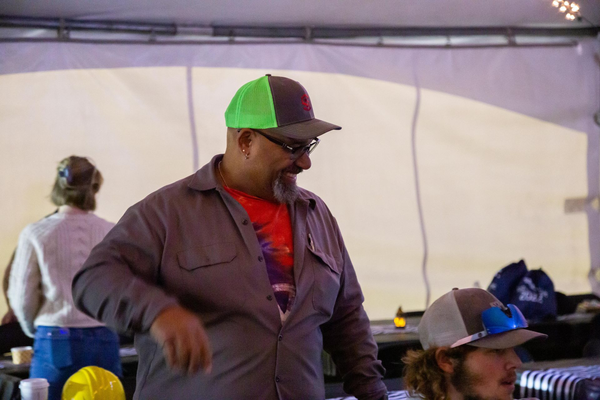 A man smiles at table of people.
