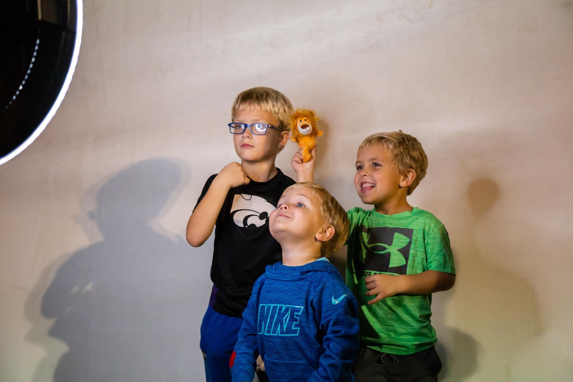 Three small kids smile for the camera.