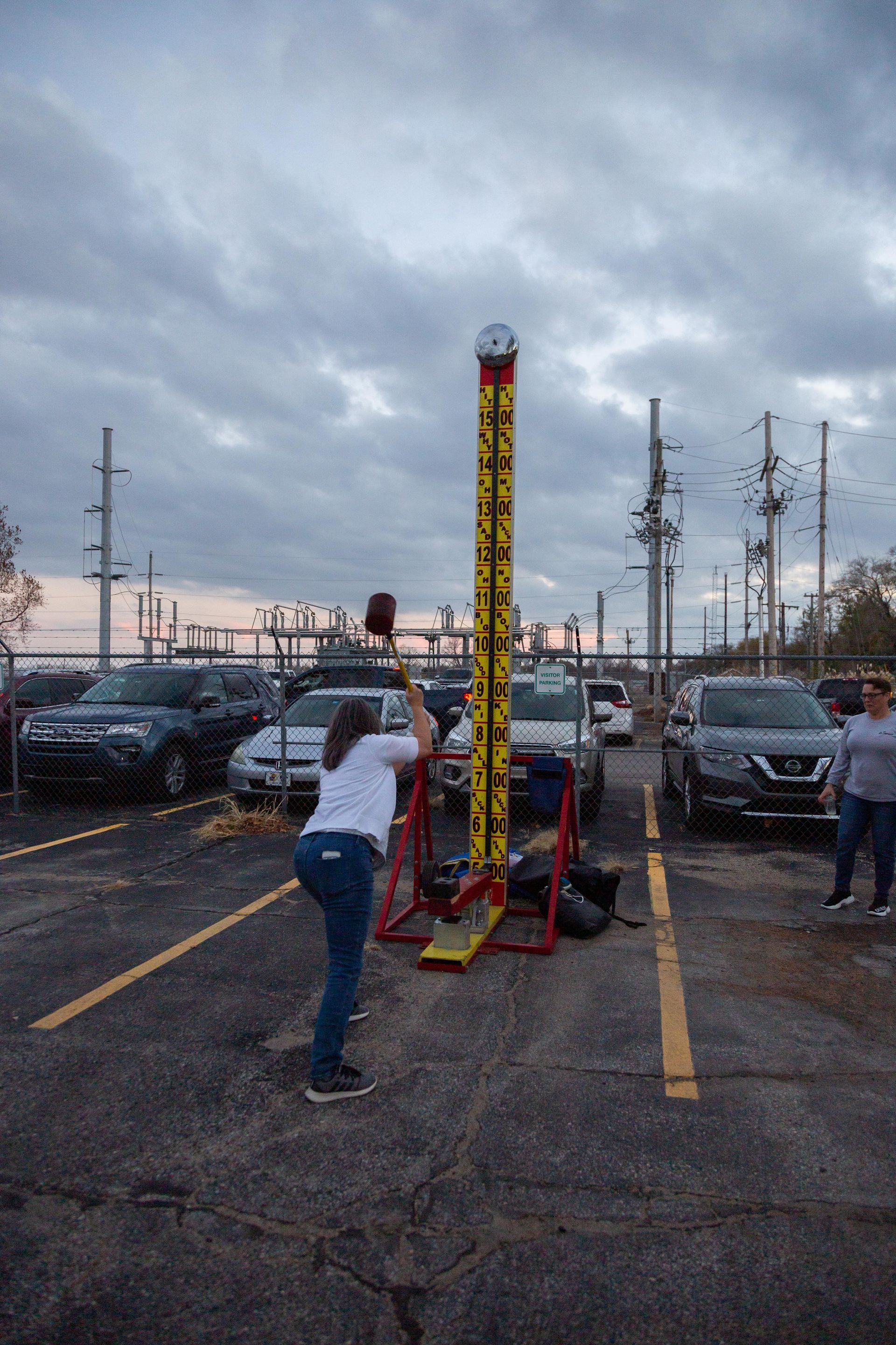 At the ICL fall family picnic has a large hammer and tried to hit a game hard to make a metal ball go up and chime a bell.