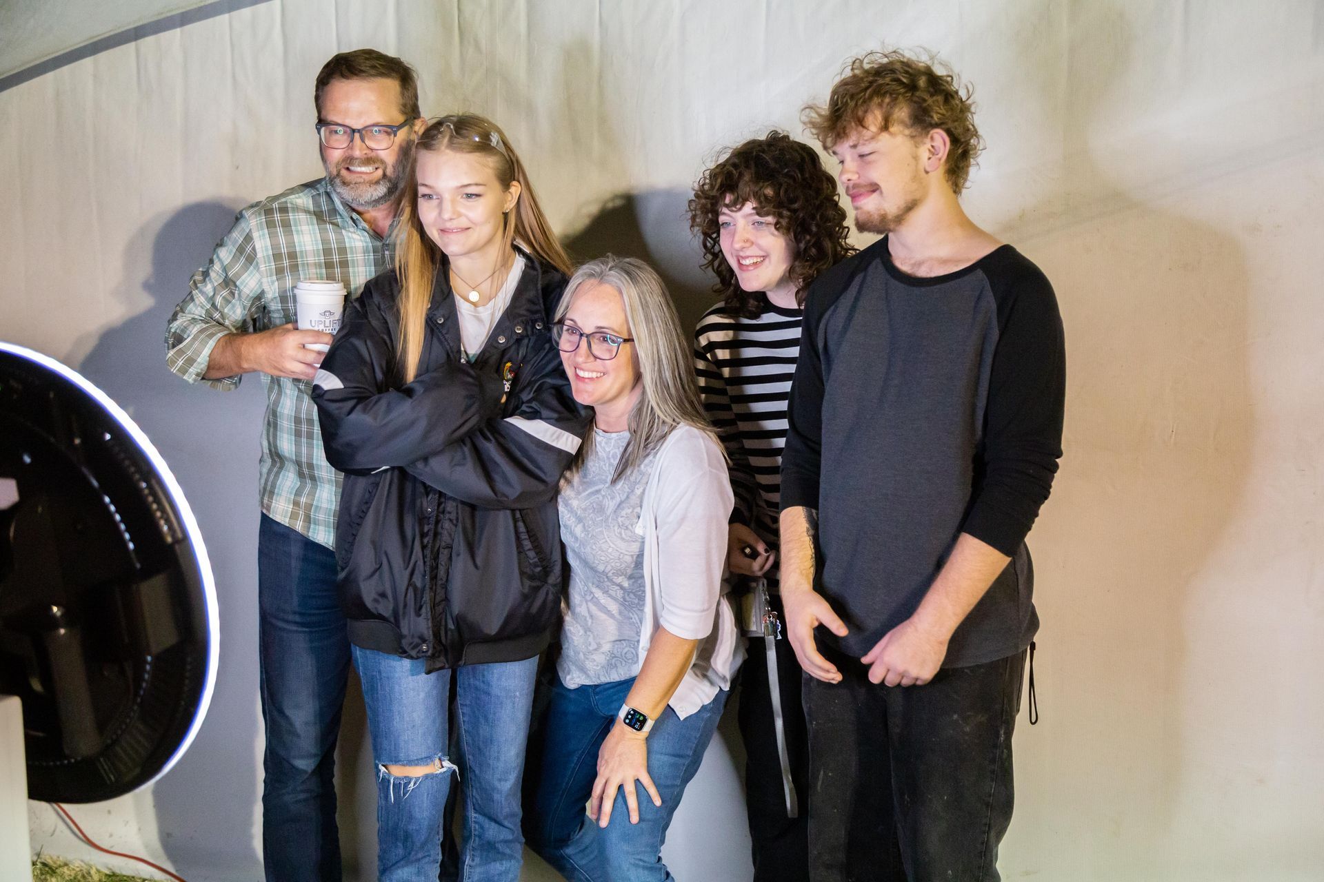 a group of people are posing for a picture in an icl photo booth .