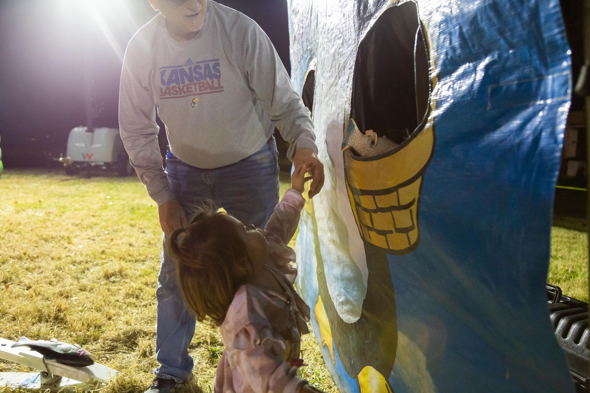 An adult helps a small child play a game.