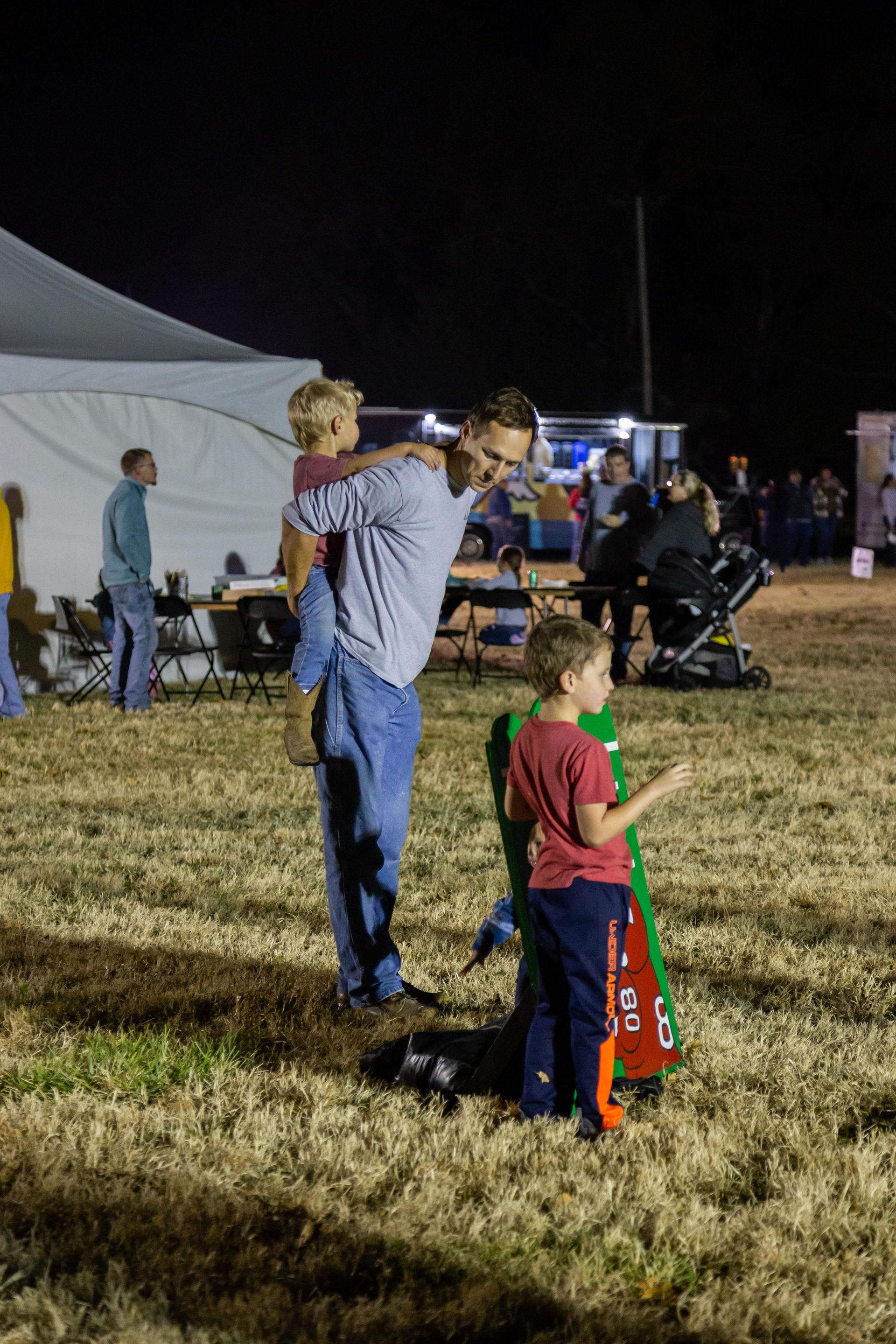 A dad gives one of his kids a piggy back ride.