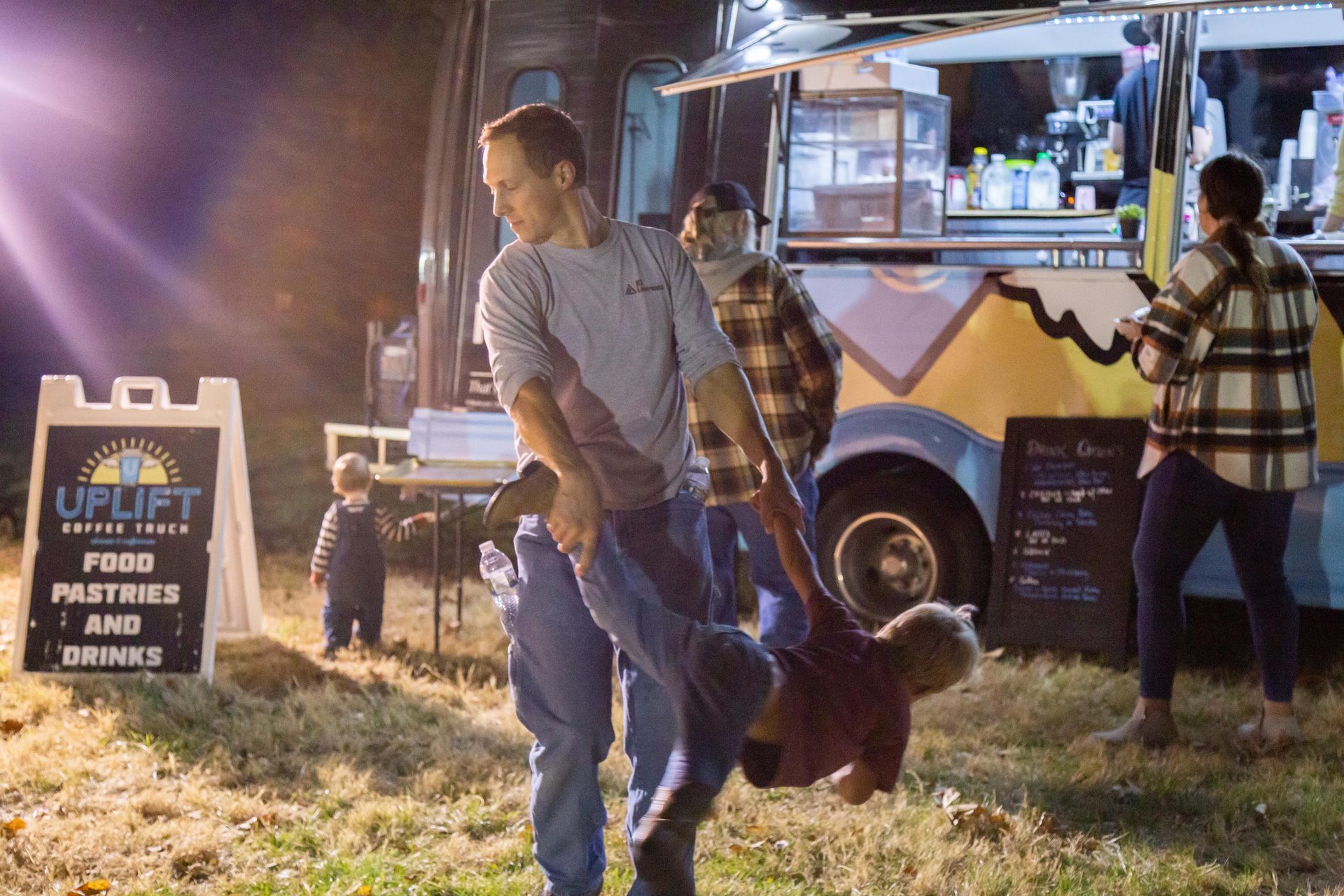A dad plays with his kids at the ICL Fall Family Picnic.