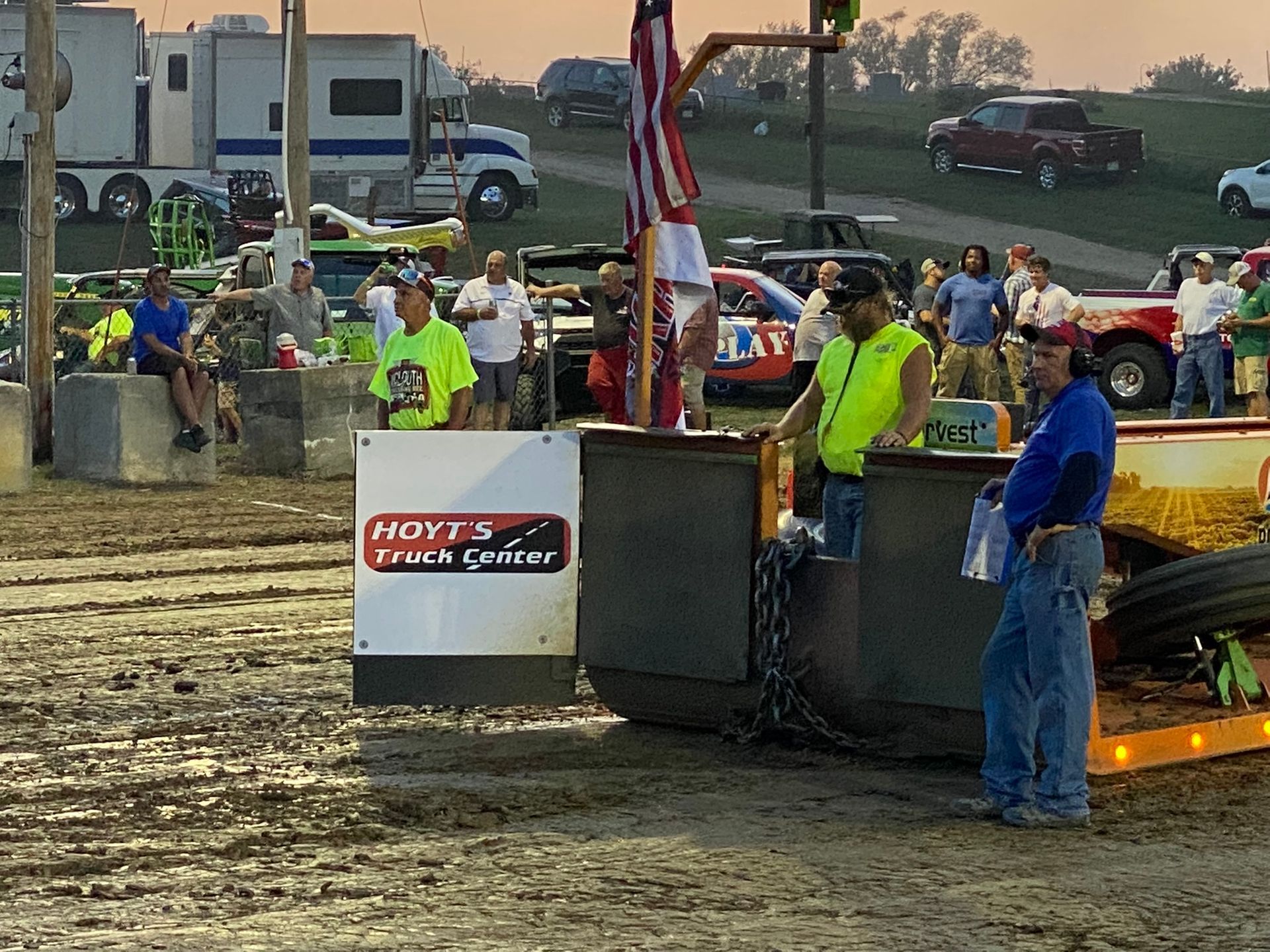 Men are standing next to a tractor.