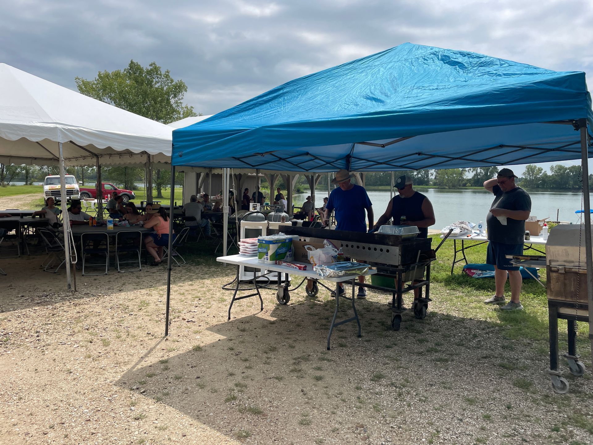 ICL summer picnic with people standing under a tent.

