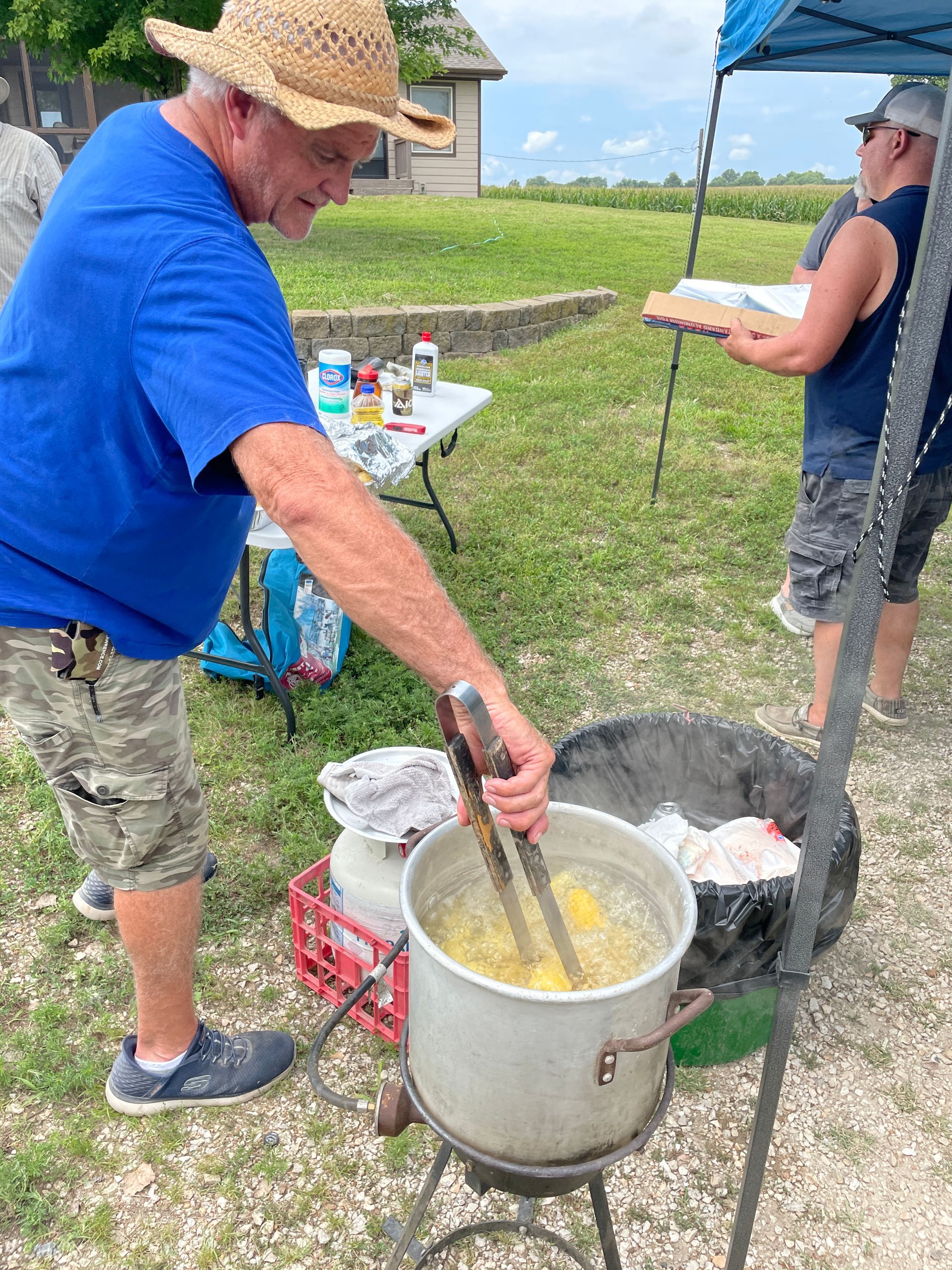 ICL picnic where a man is boiling corn.