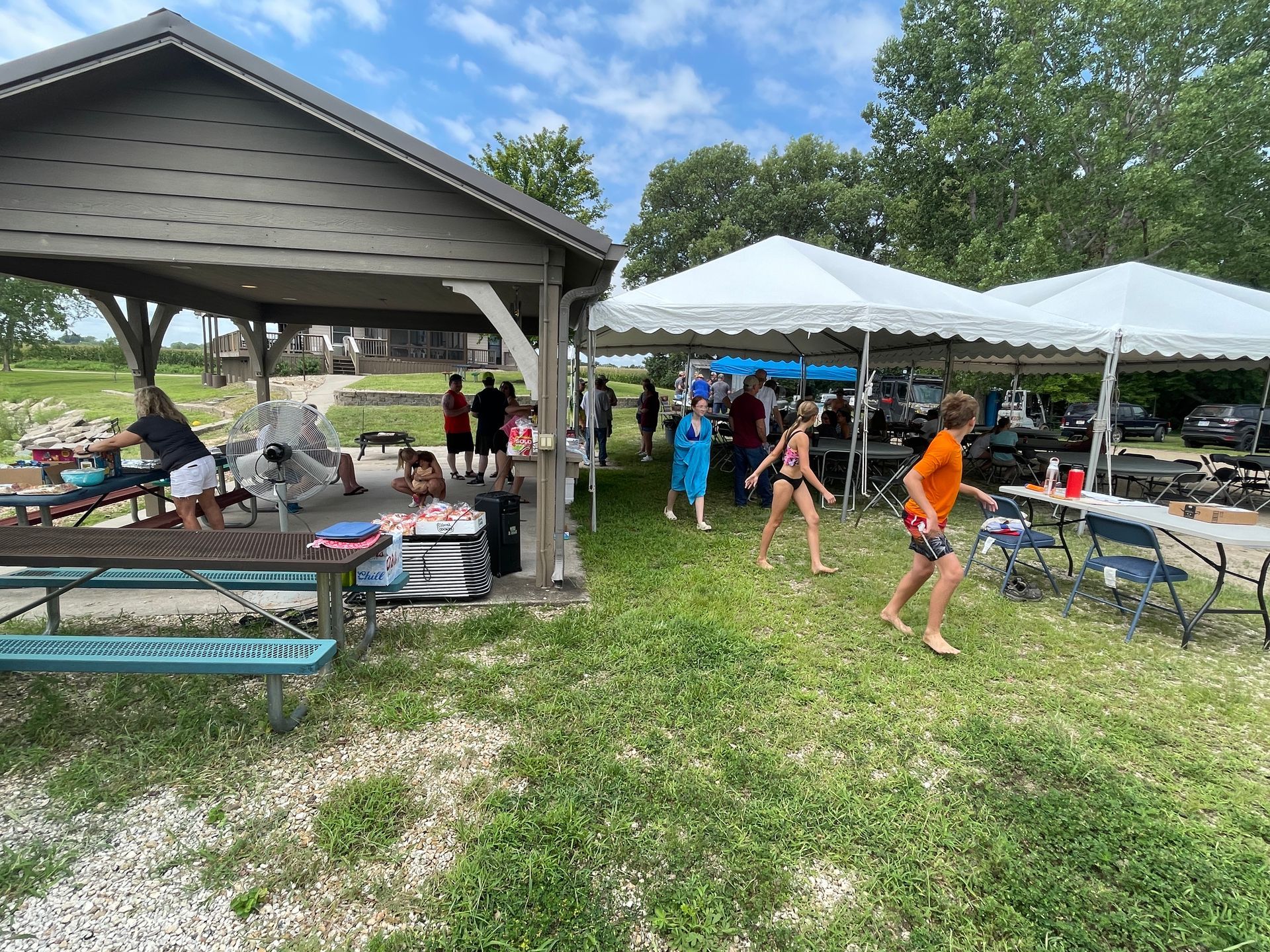 ICL summer picnic with people standing under a tent.