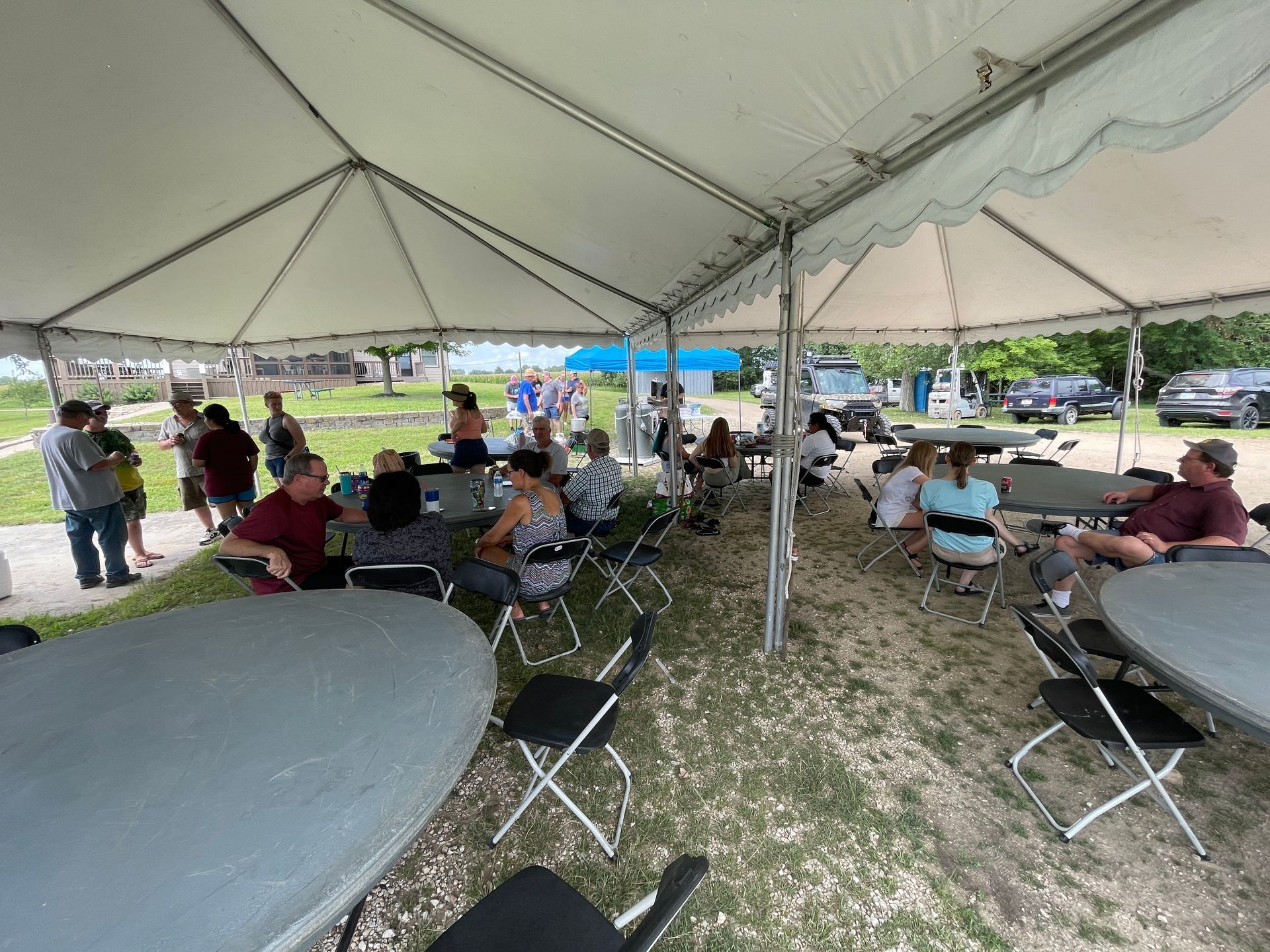 ICL summer picnic with people standing under a tent.