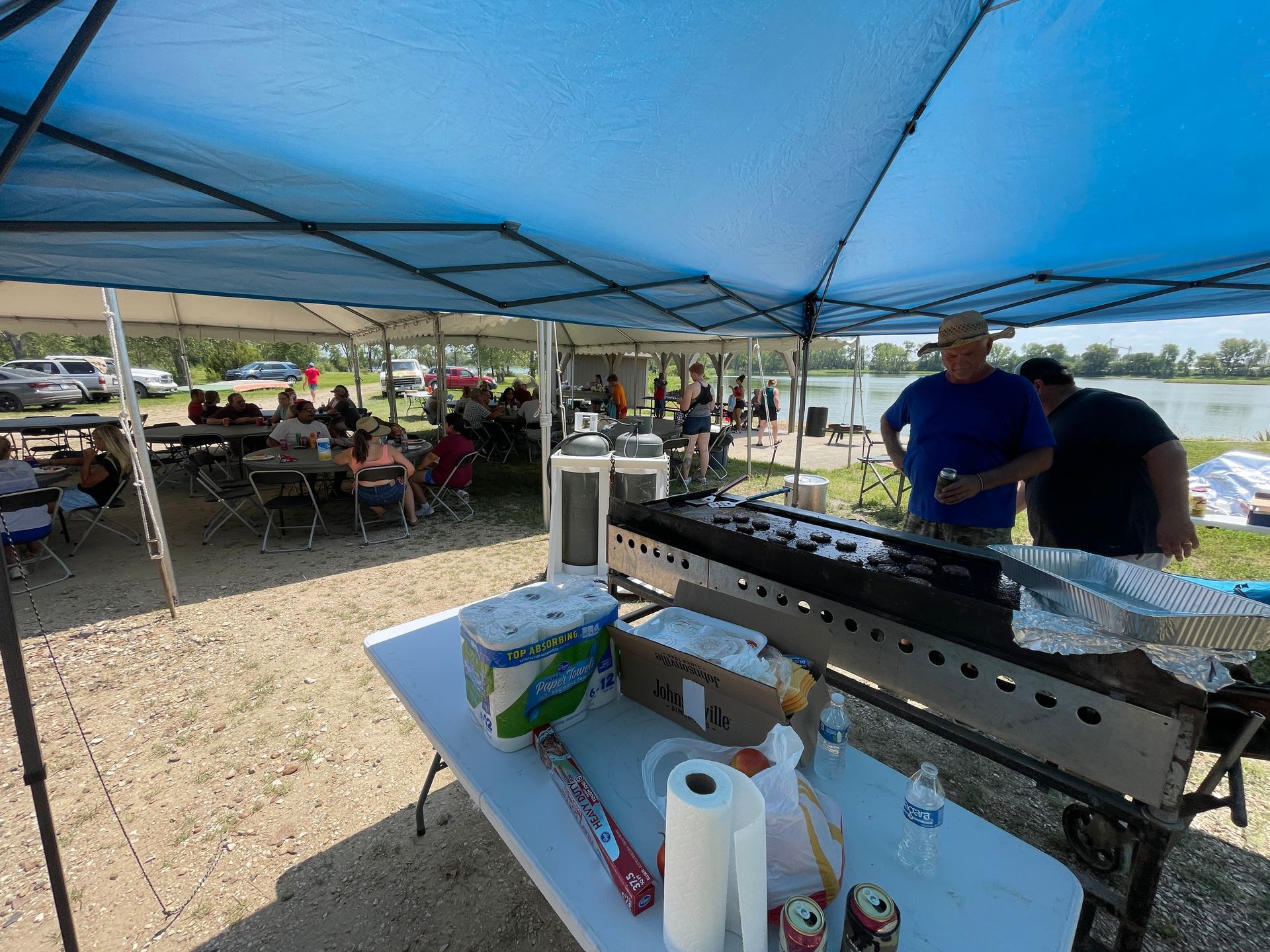 ICL summer picnic with people standing under a tent.