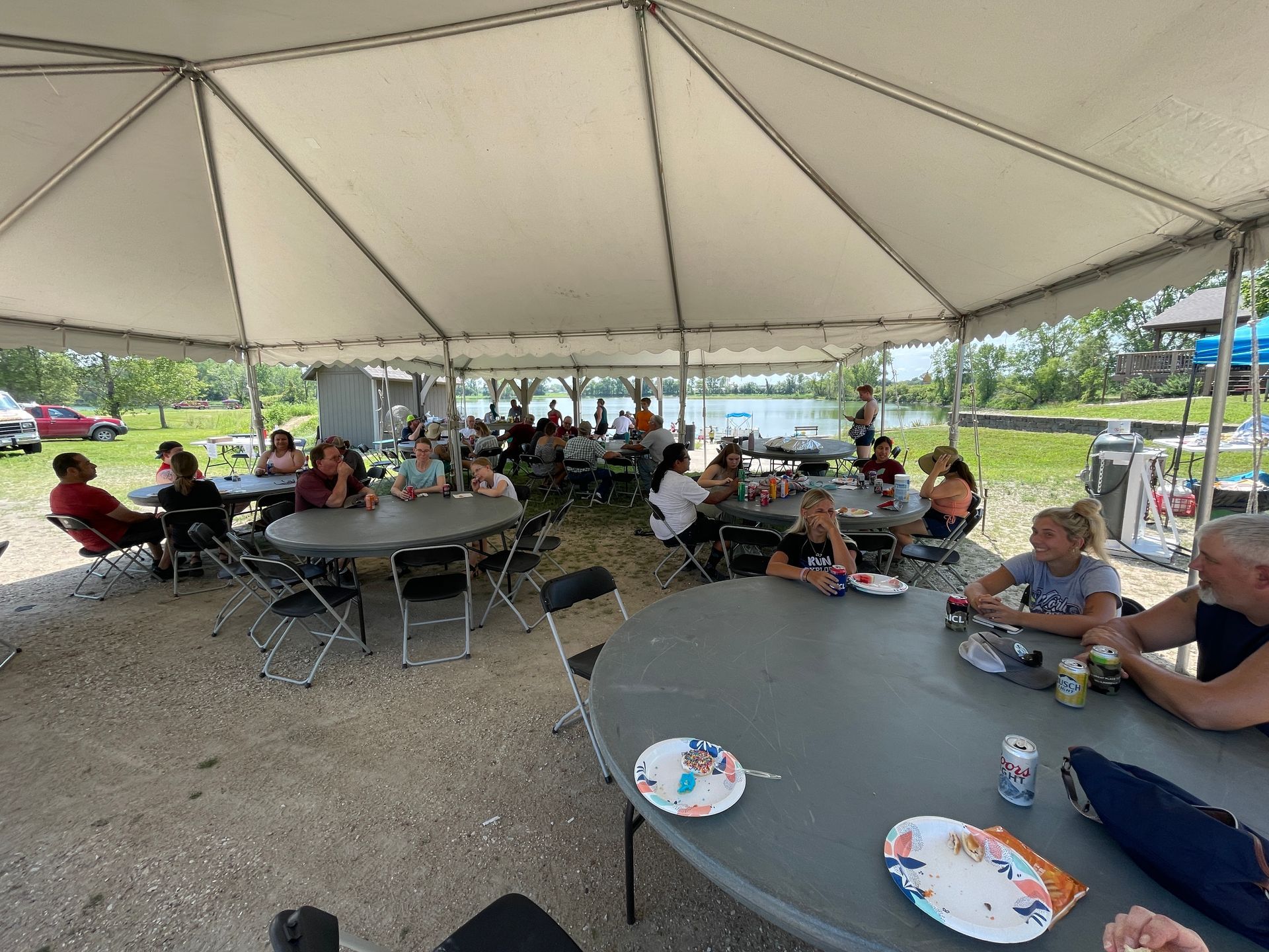 ICL picnic where people are sitting under a tent.