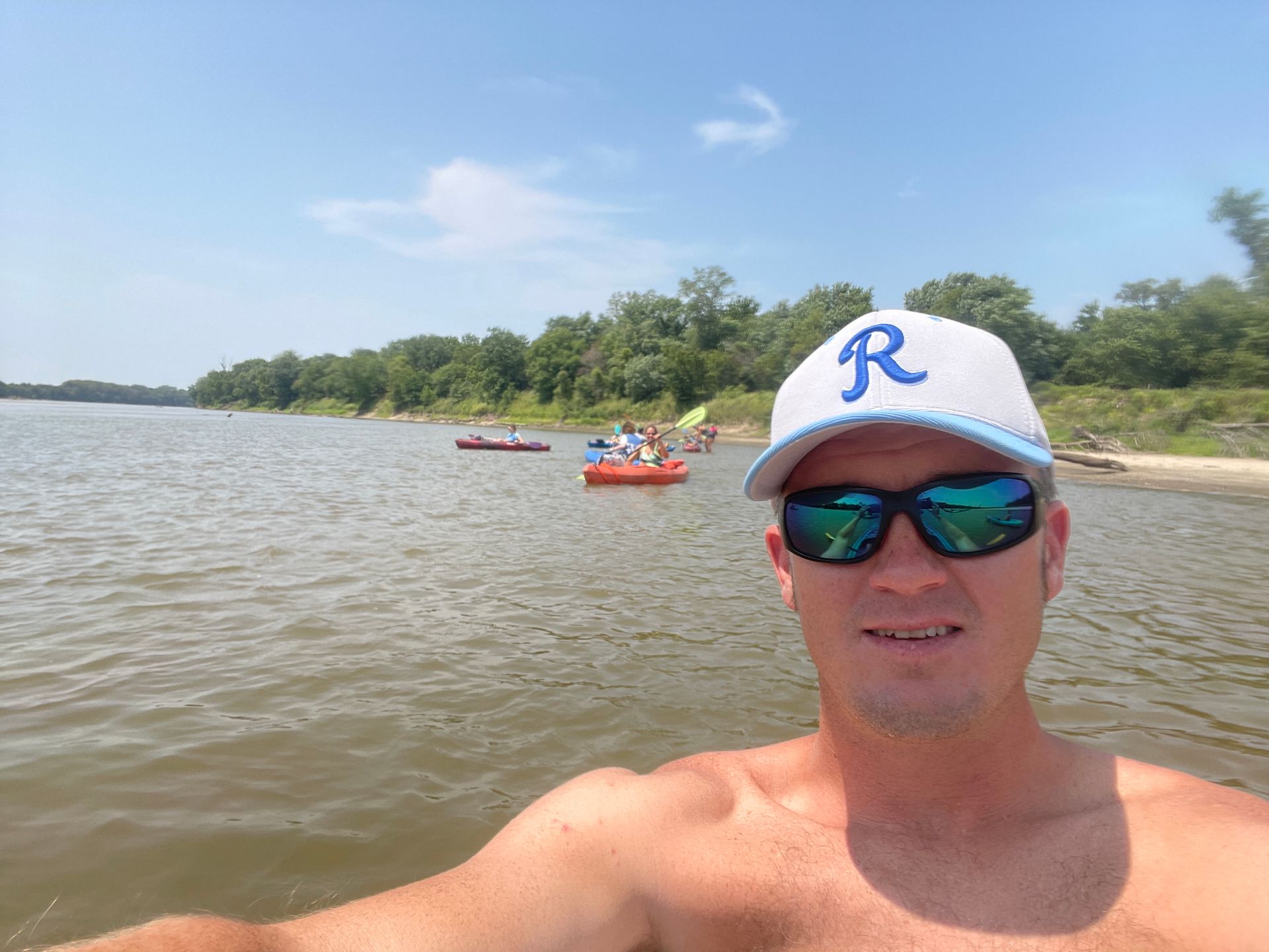 A man is standing in the river smiling.