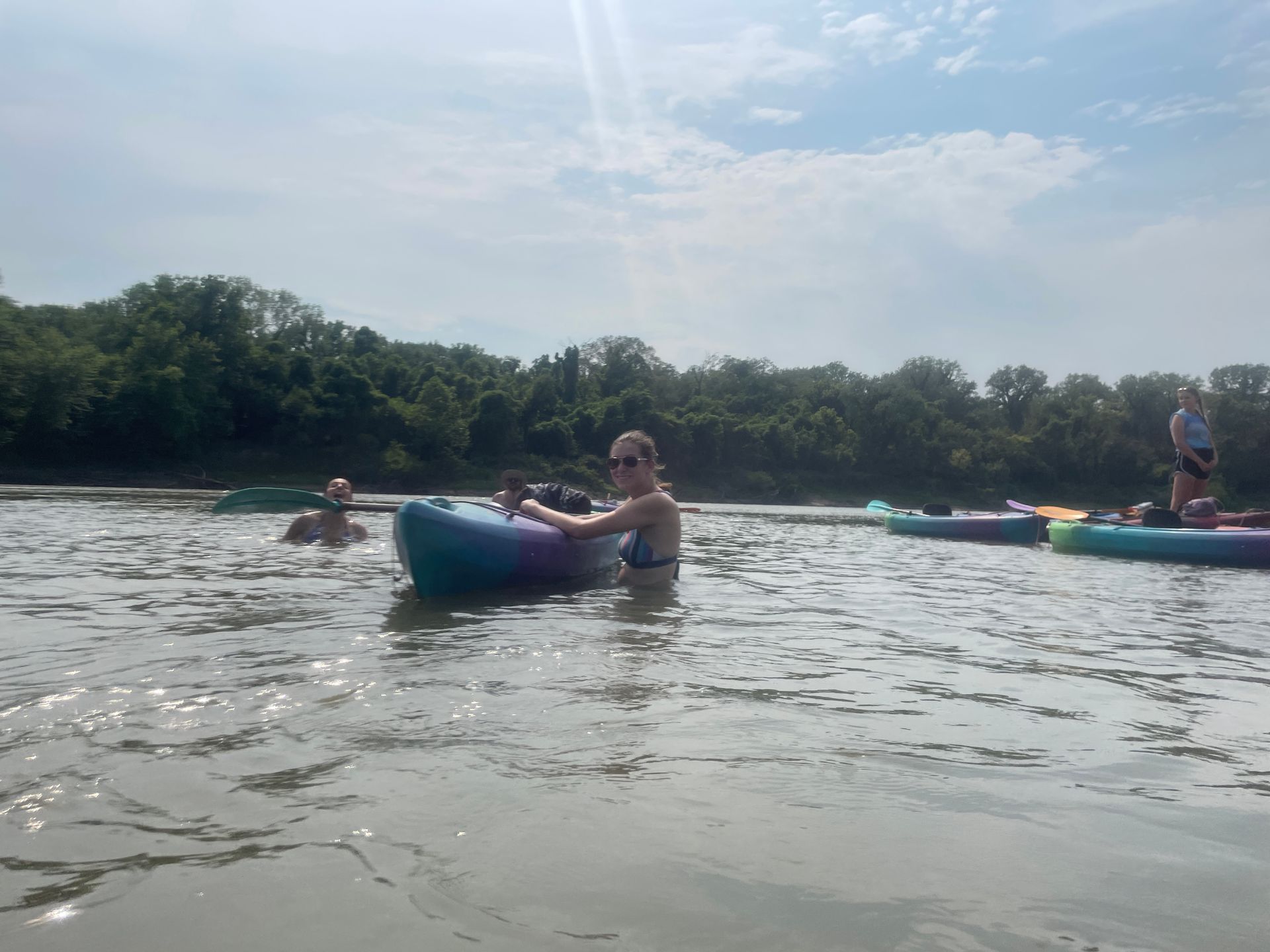 Group of ICL employees standing in a river and getting ready to float in a boat.