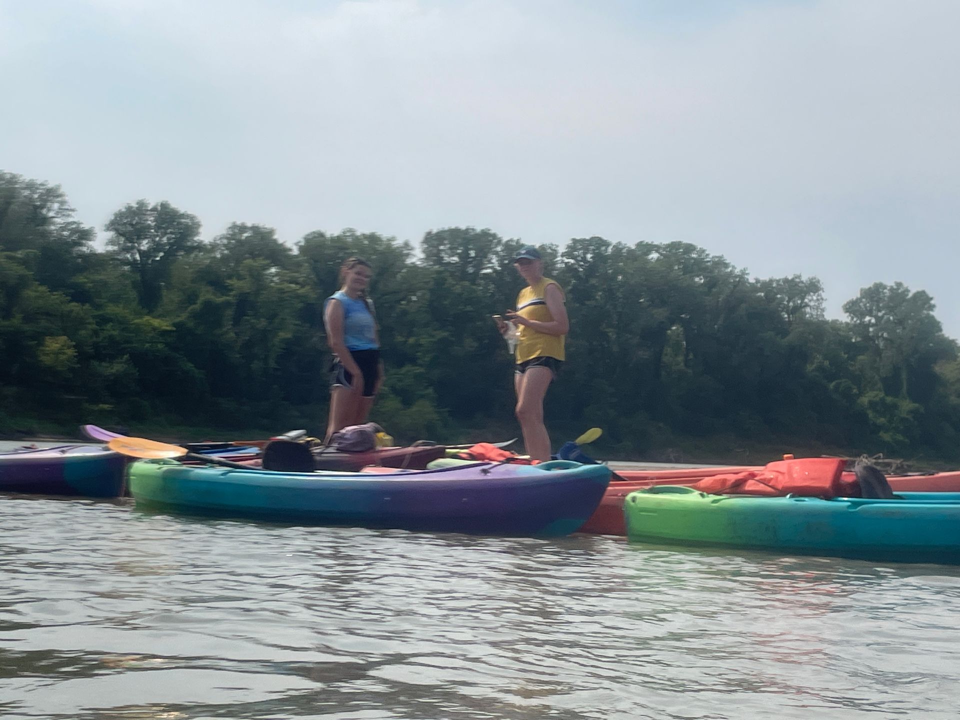 Group of ICL employees standing in a river and getting ready to float in a boat.