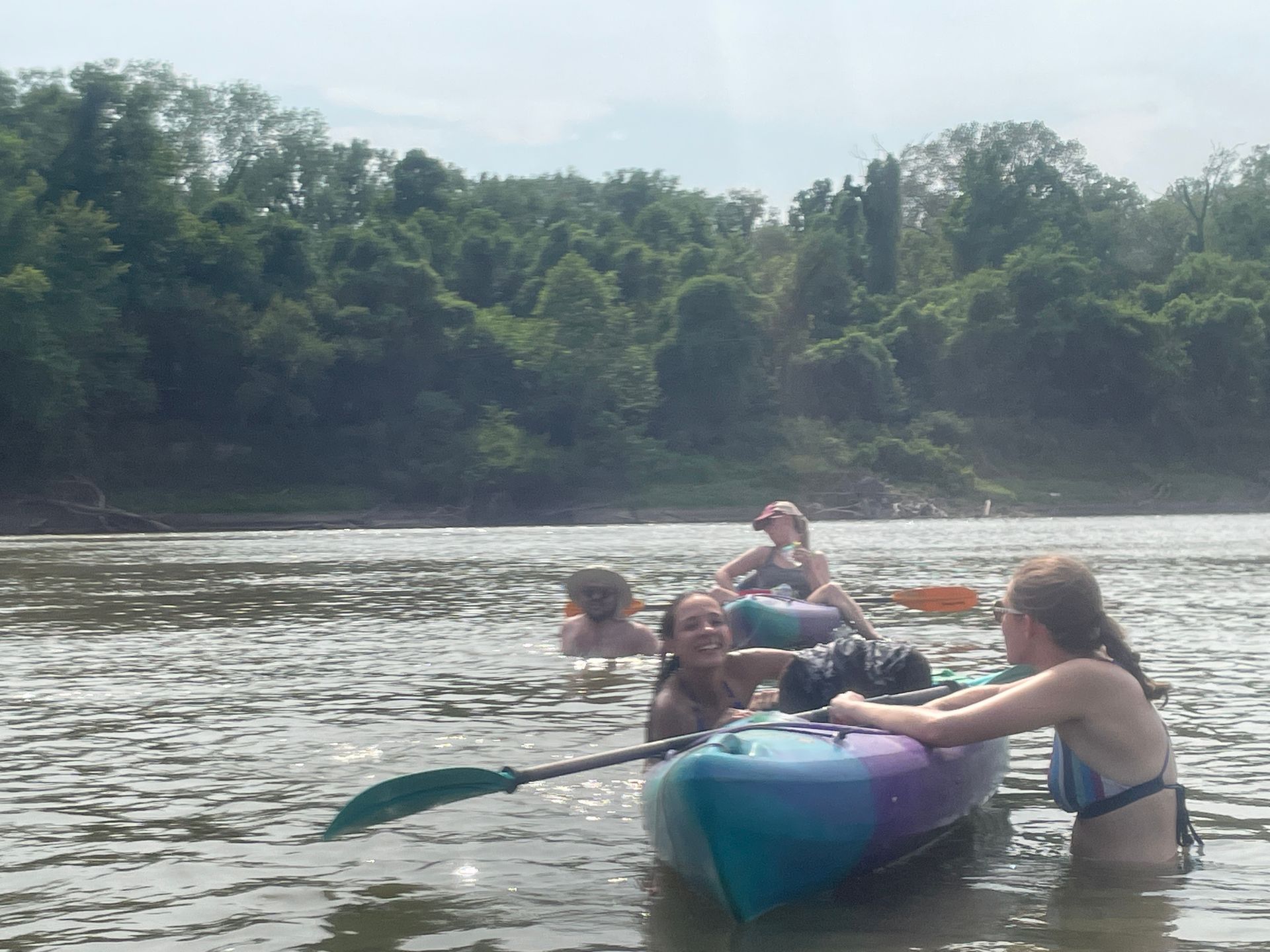 Group of ICL employees standing in a river and getting ready to float in a boat.