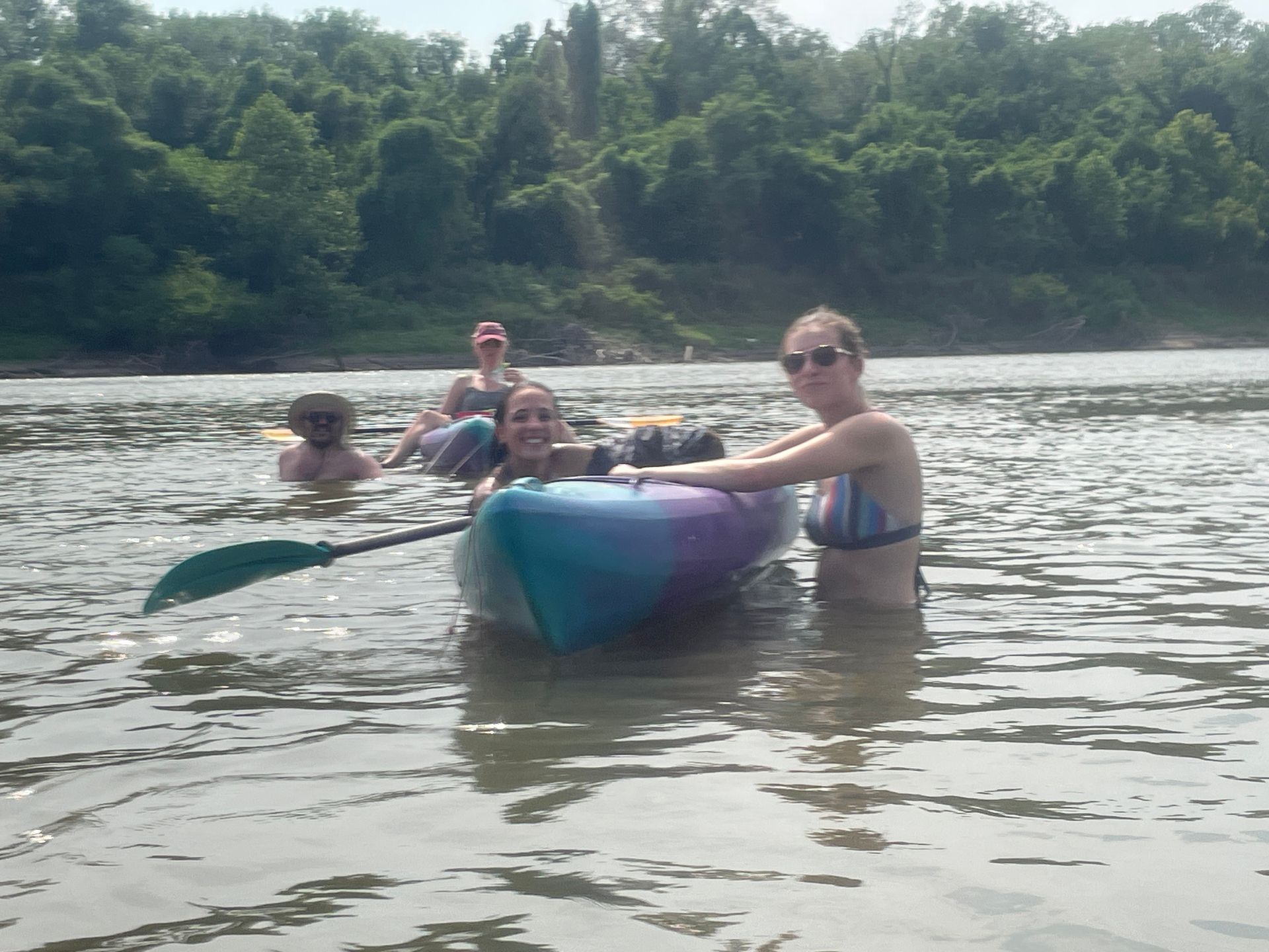 Group of ICL employees standing in a river and getting ready to float in a boat.
