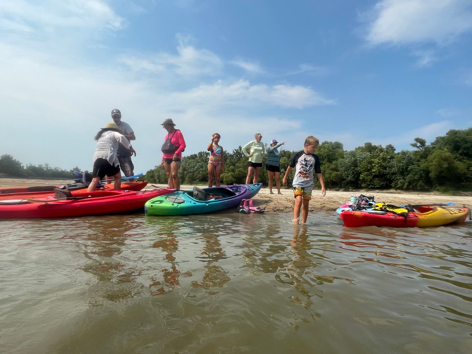Group of ICL employees standing by a river and getting ready to float in a boat.