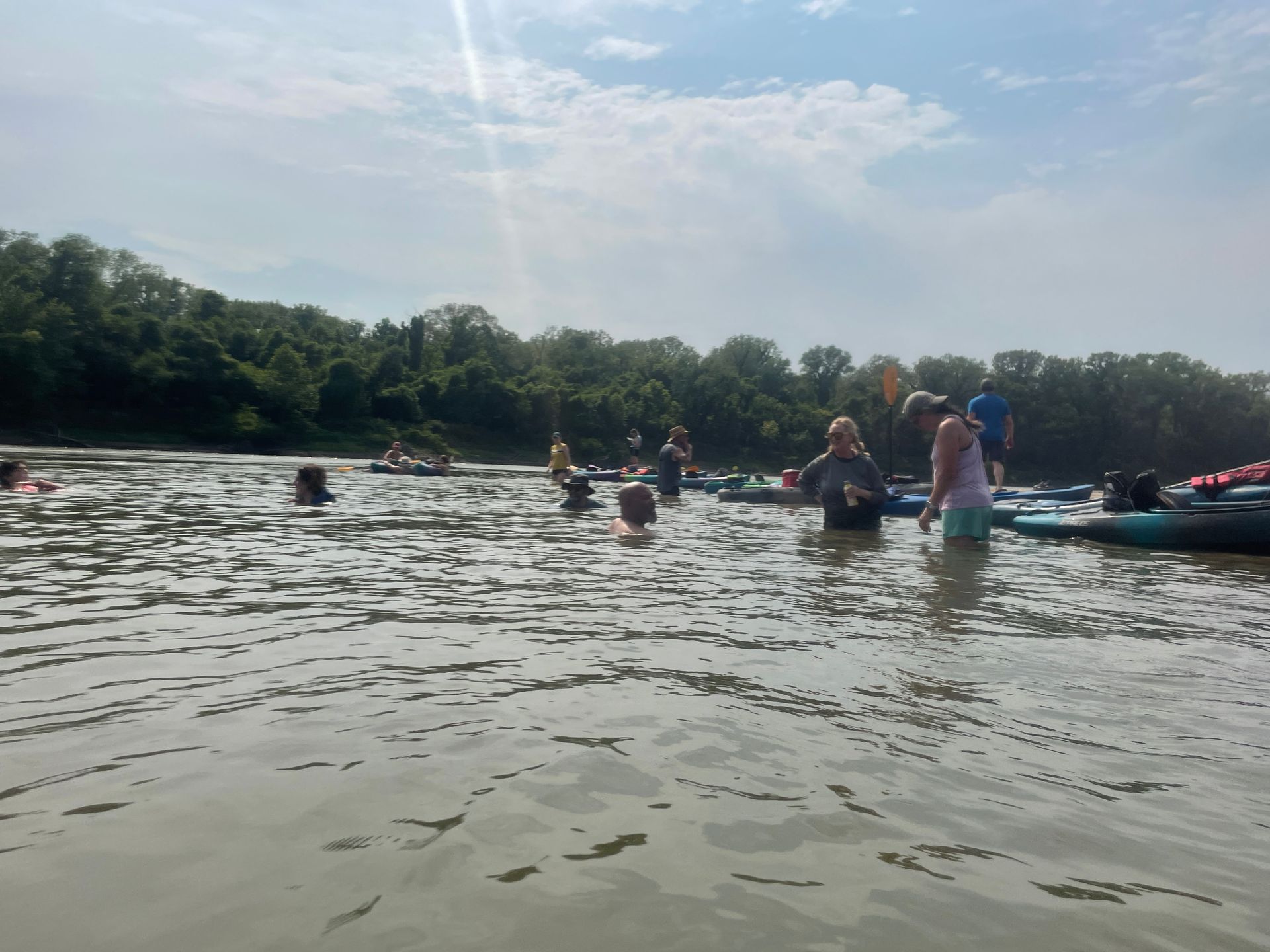 Group of ICL employees standing in a river and getting ready to float in a boat.