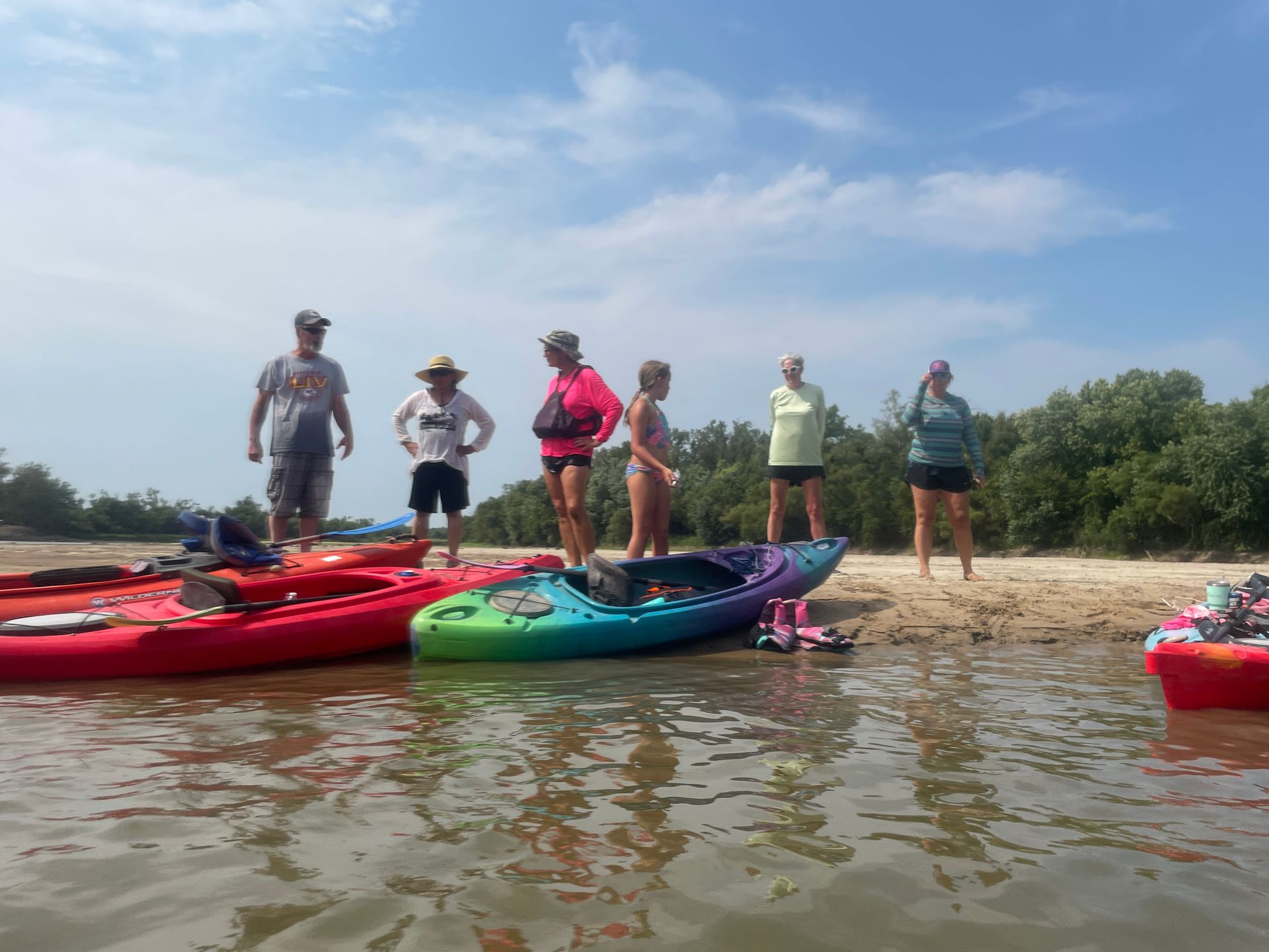 Group of ICL employees standing by a river and getting ready to float in a boat.