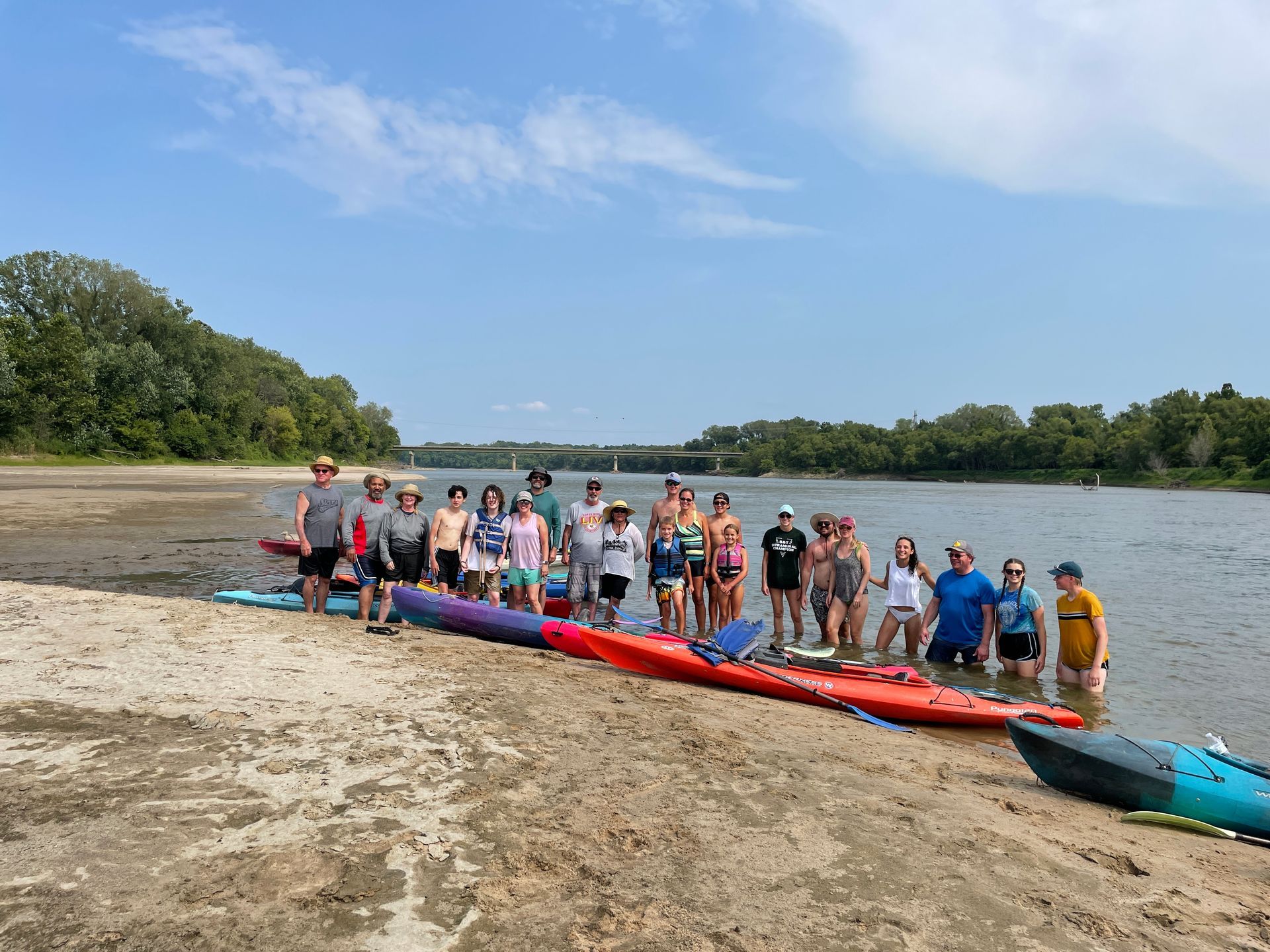 Group of ICL employees standing by a river and getting ready to float in a boat.