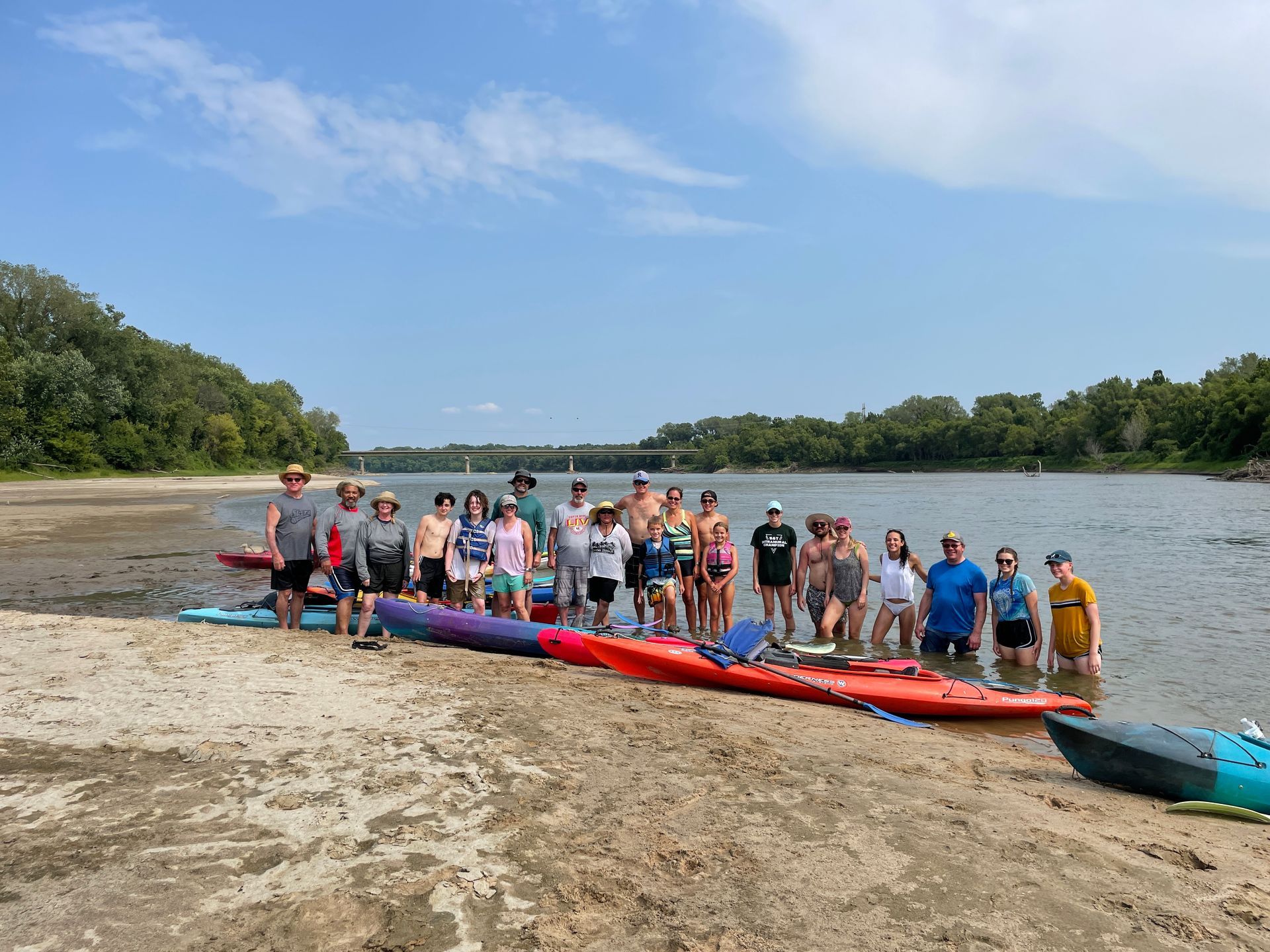 Group of ICL employees standing by a river and getting ready to float in a boat.