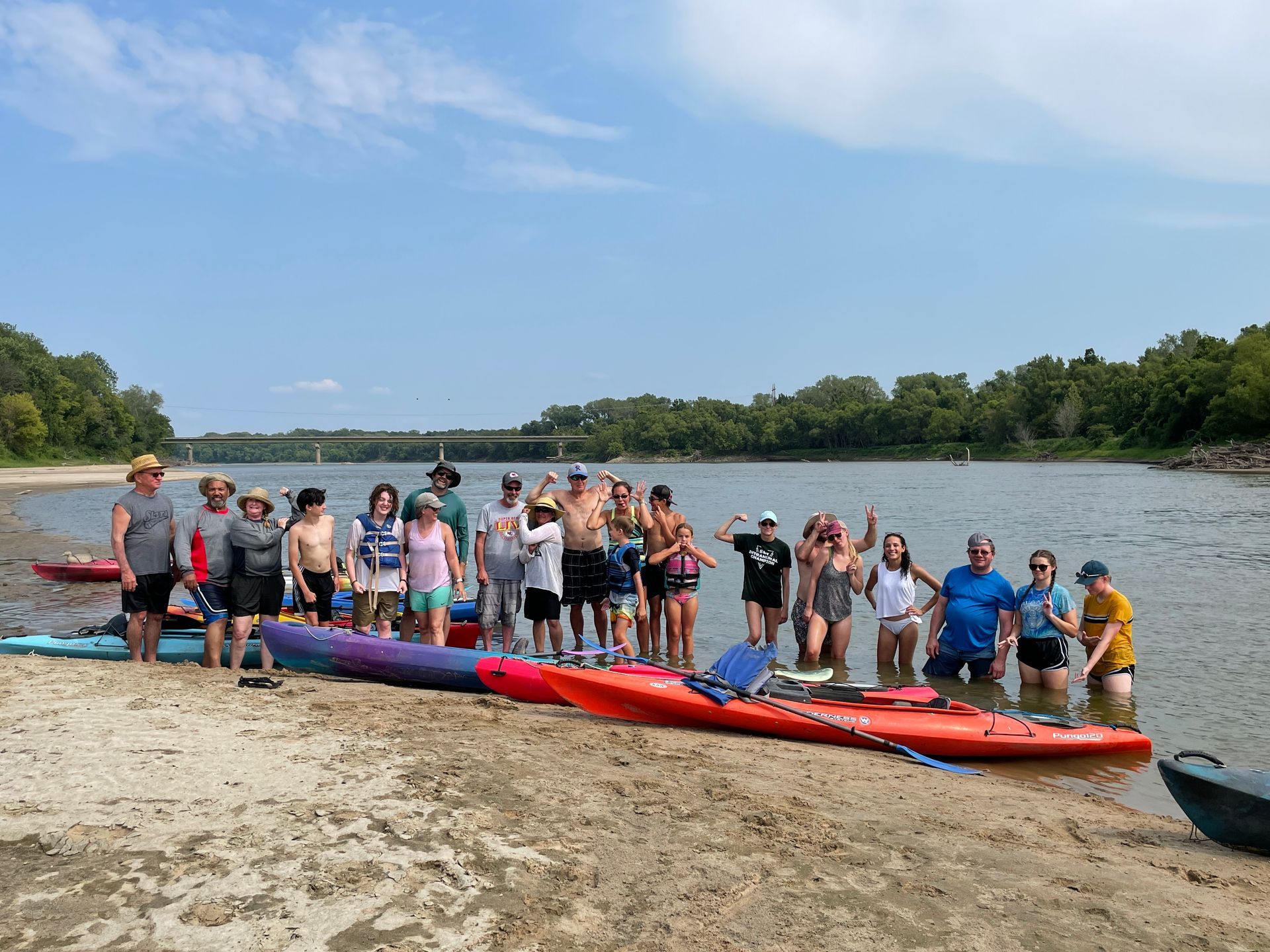 Group of ICL employees standing by a river and getting ready to float in a boat.
