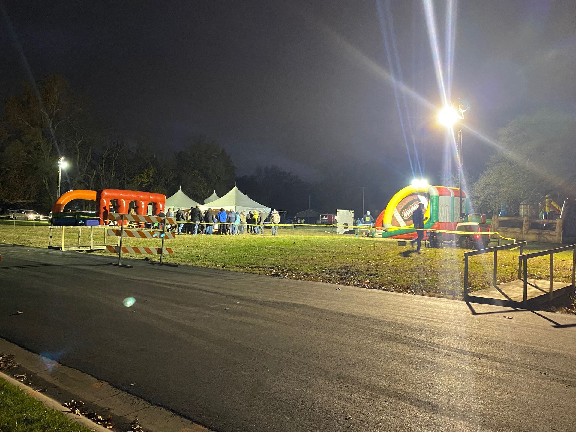 A group of people are standing in a field at night.