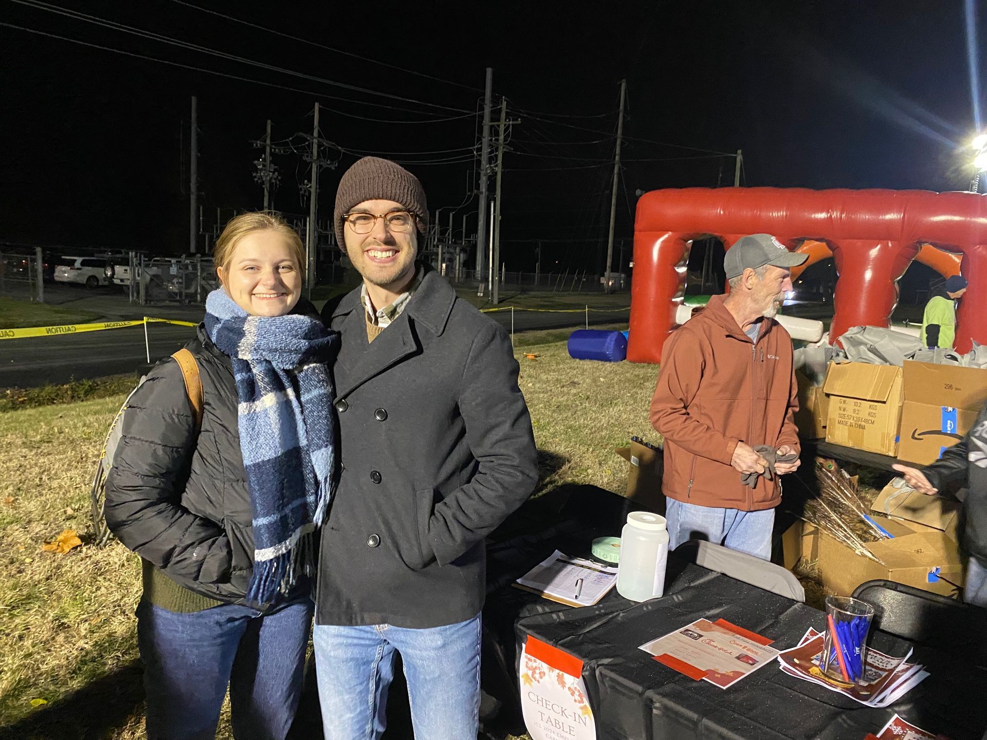 A man and a woman are standing next to each other in front of a table.