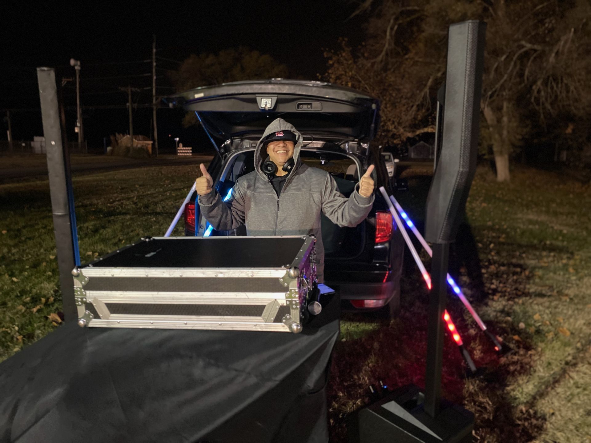 A man in a hooded jacket is standing in the back of a truck.