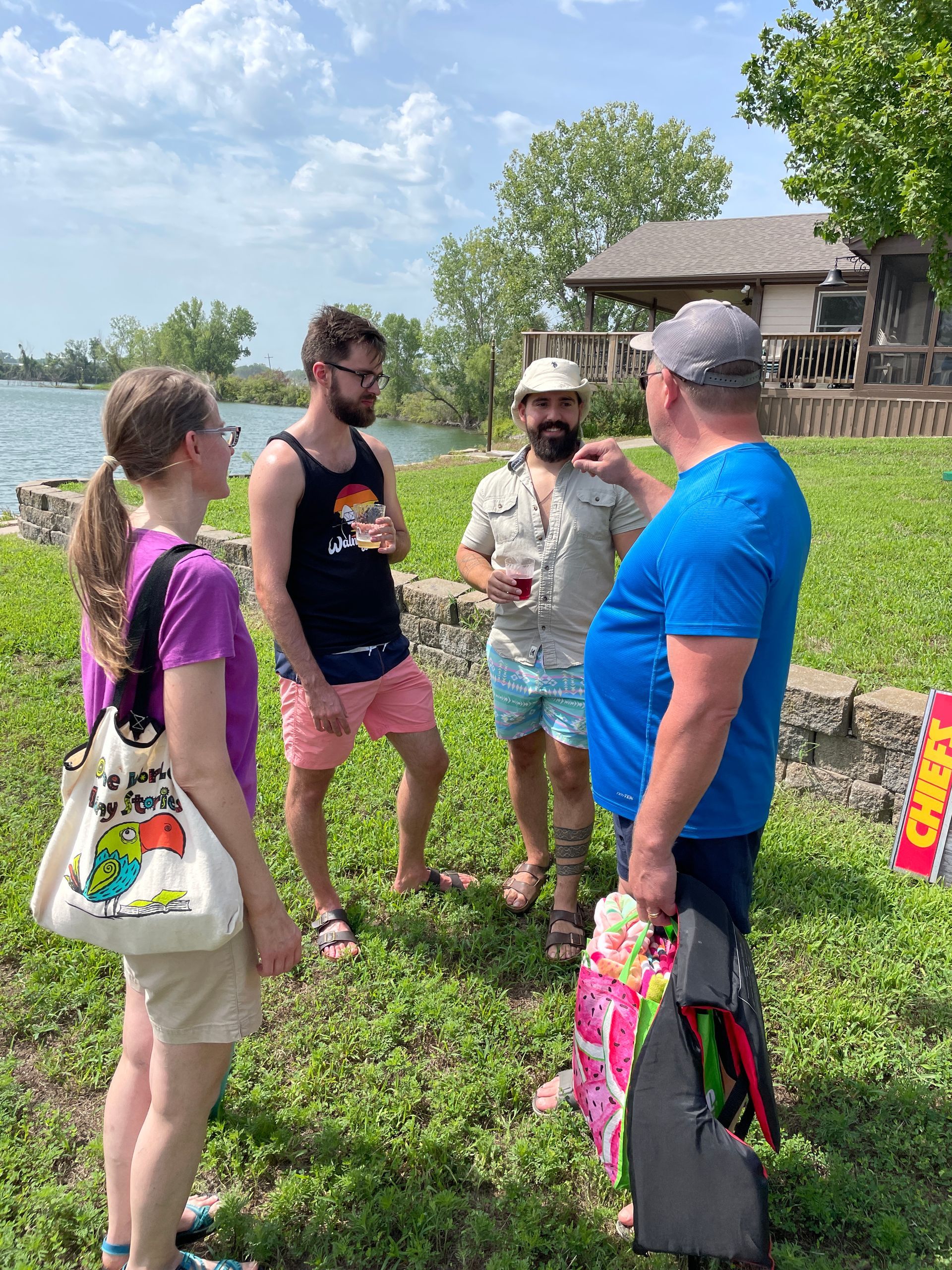 Adults are standing around at the picnic talking.