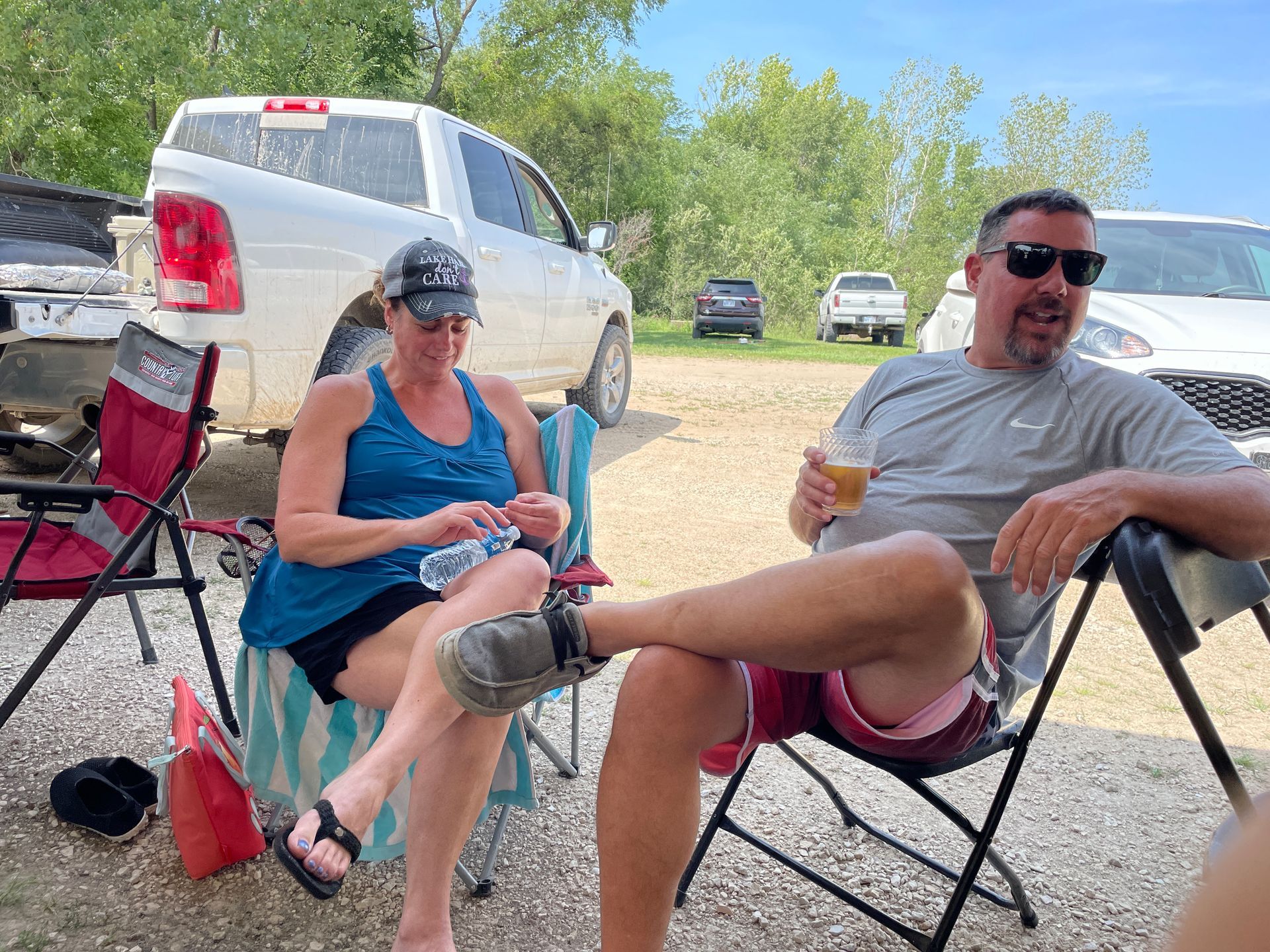 A amn and a woman are sitting in lawn chairs and smiling and talking.