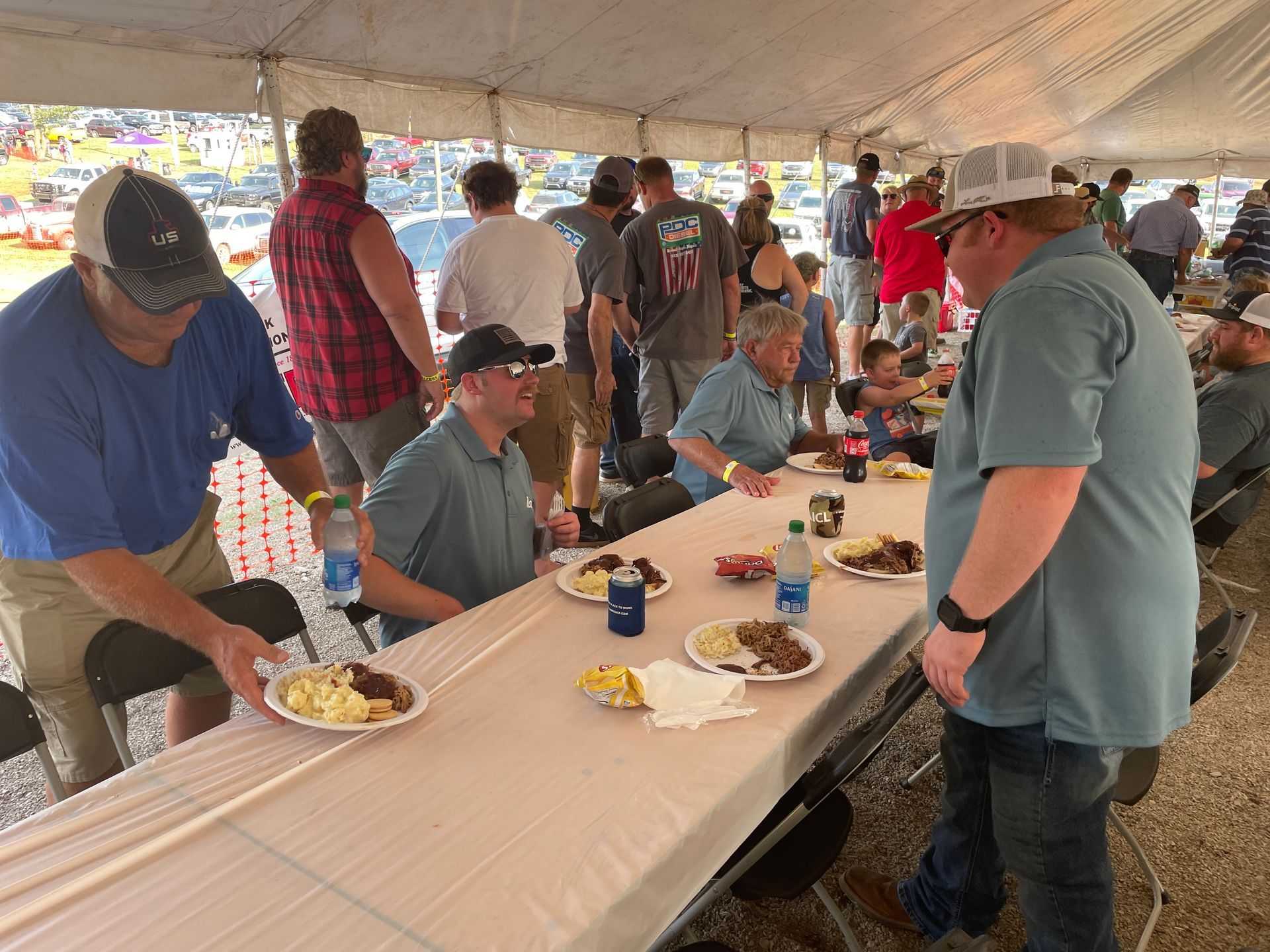 Men sitting a a picnic table to eat some food.