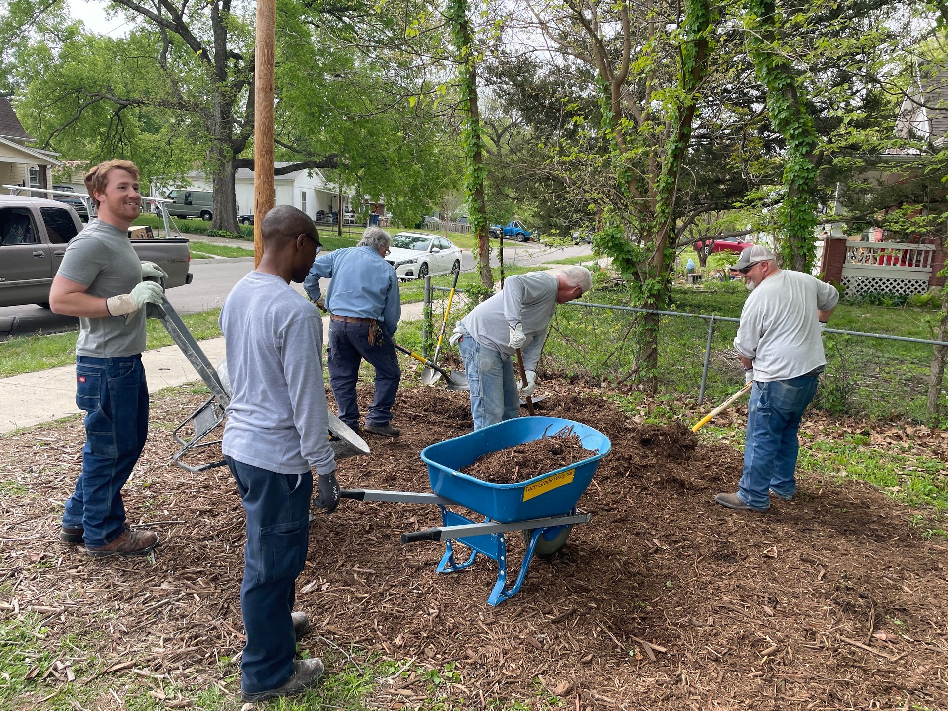 Group of men are moving mulch the the Community Garden.