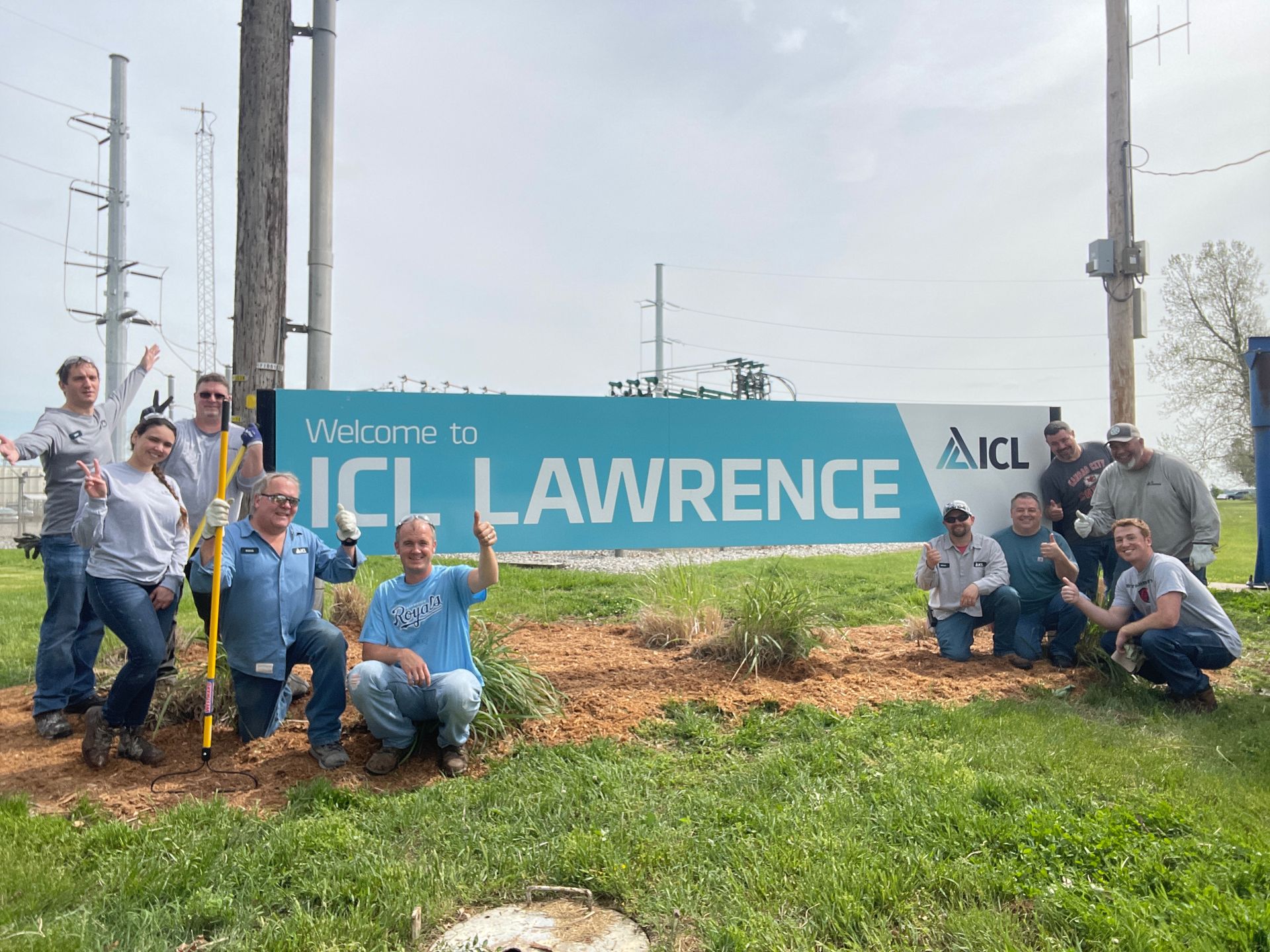 ICL employees are standing around an ICL Lawrence sign.