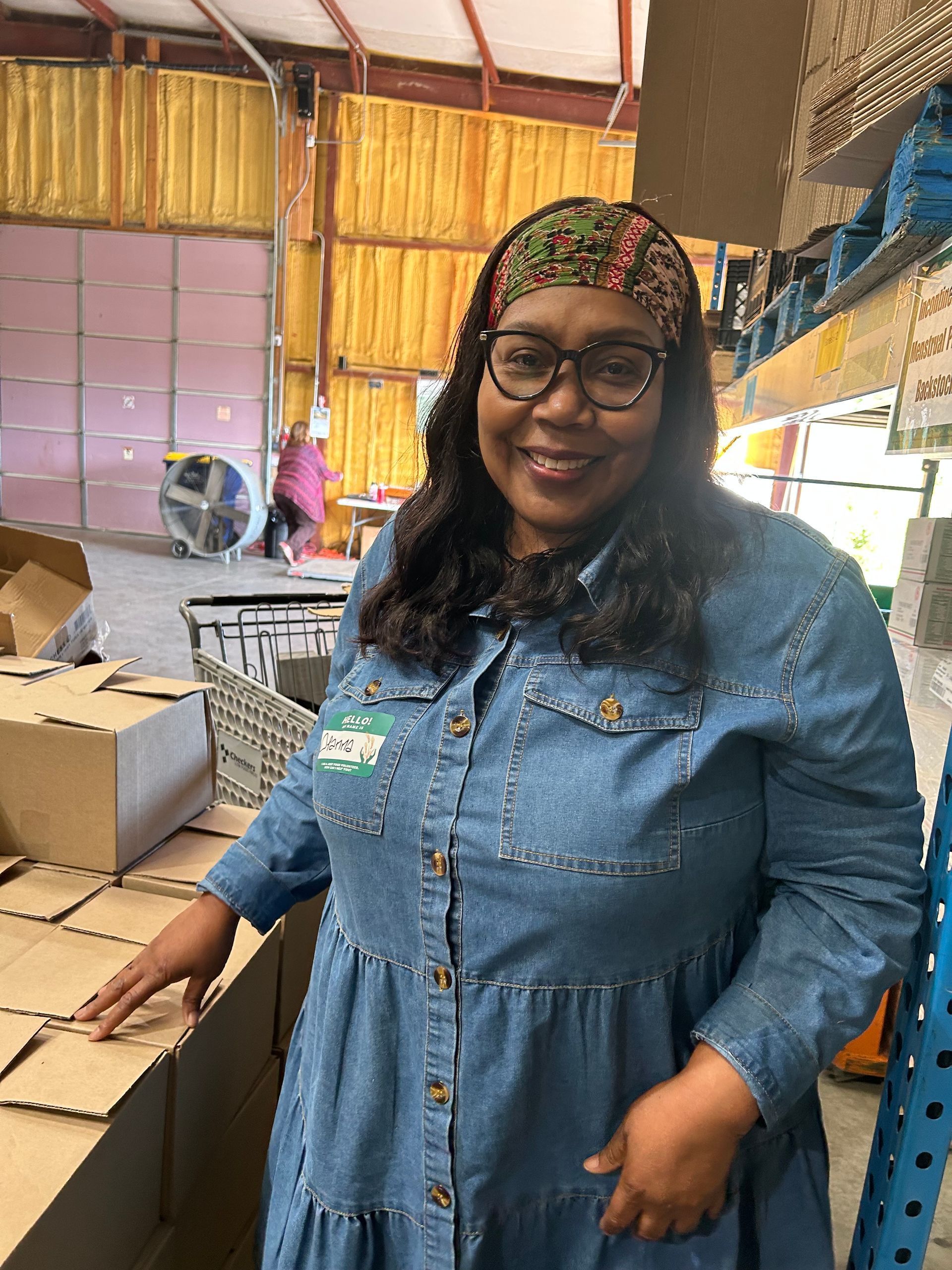 A woman smiles for the camera at the community food drive.