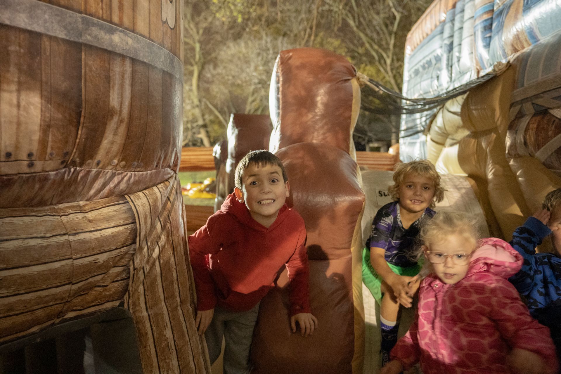A group of children are playing in a wooden maze.