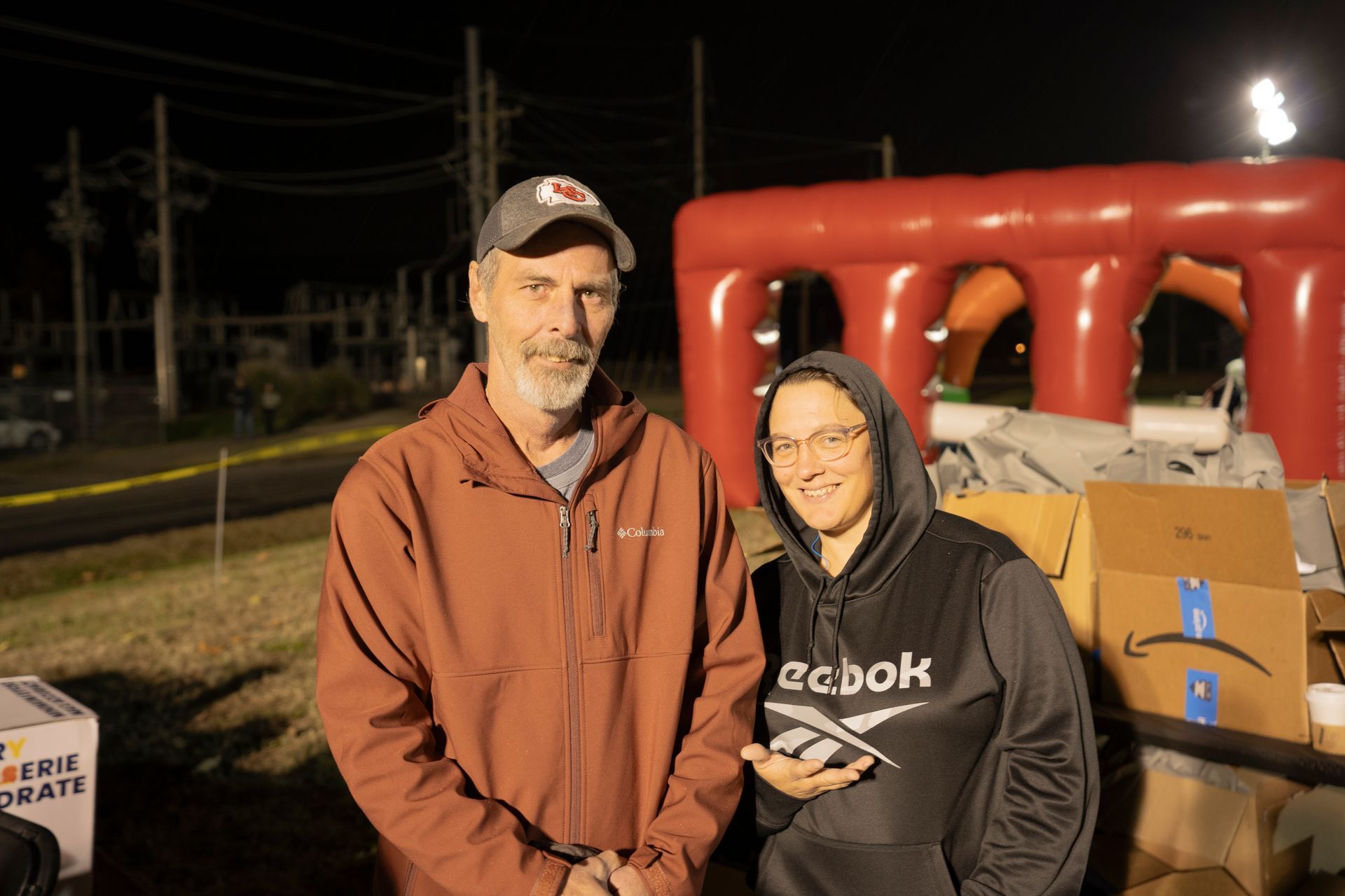 A man and a woman are standing next to each other in front of an inflatable raft.