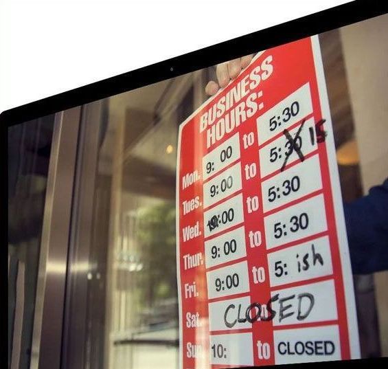 A person holding a business hours sign, with 