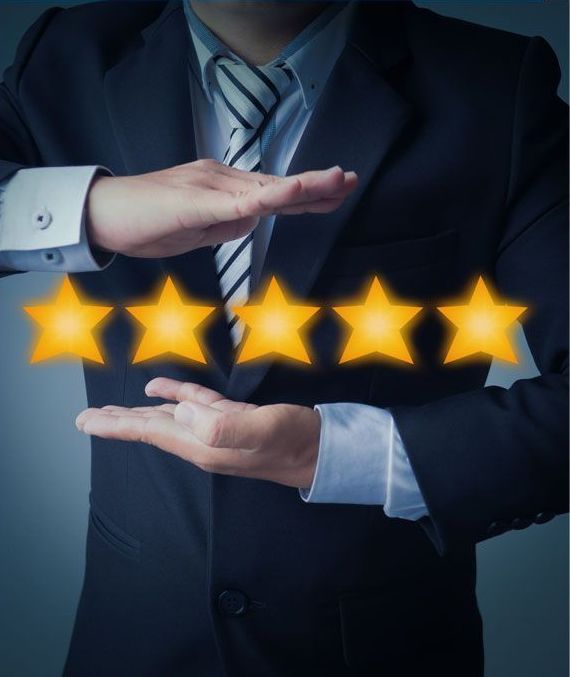 Man in a suit holding up glowing gold stars, symbolizing a five-star rating or excellent review.