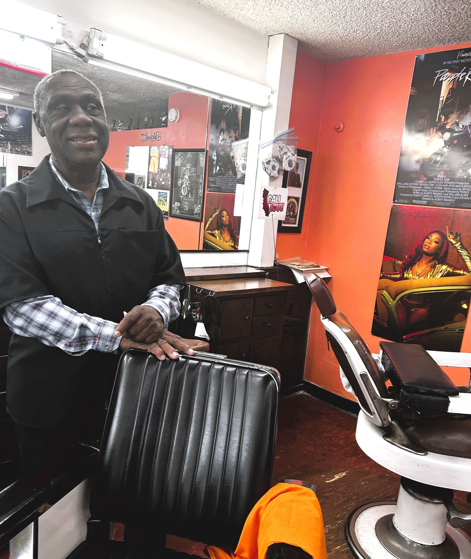 A man standing next to a barber chair in a barber shop
