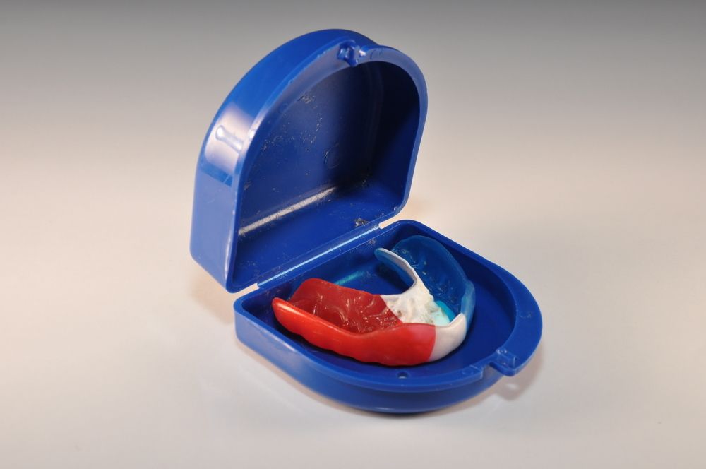 A Red White And Blue Mouth Guard In A Blue Case — Dentures Direct Taree-Rod Hinton In Taree, NSW
