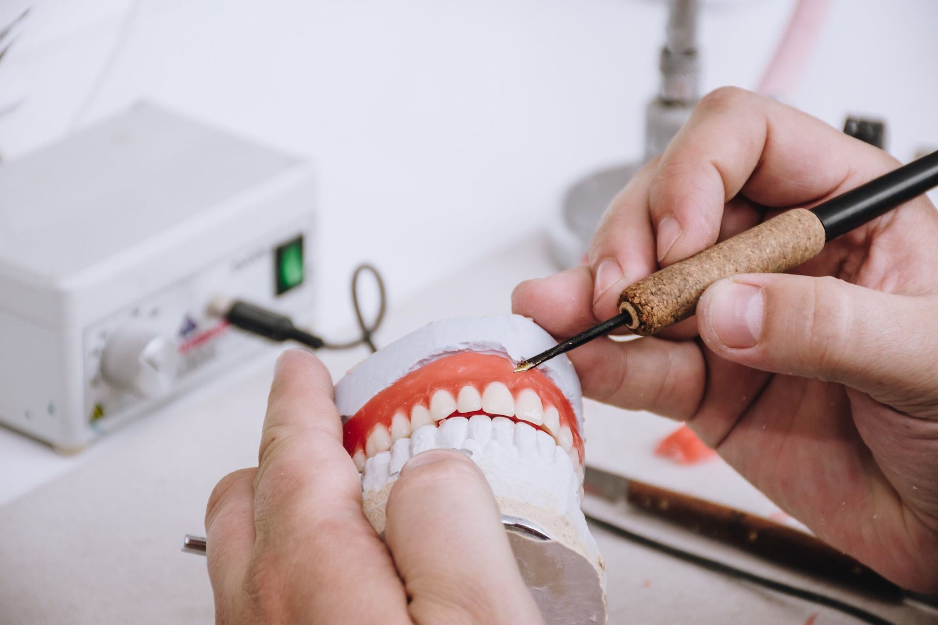 A Dentist Is Working On A Model Of A Person 's Teeth — Dentures Direct Taree-Rod Hinton In Taree, NSW